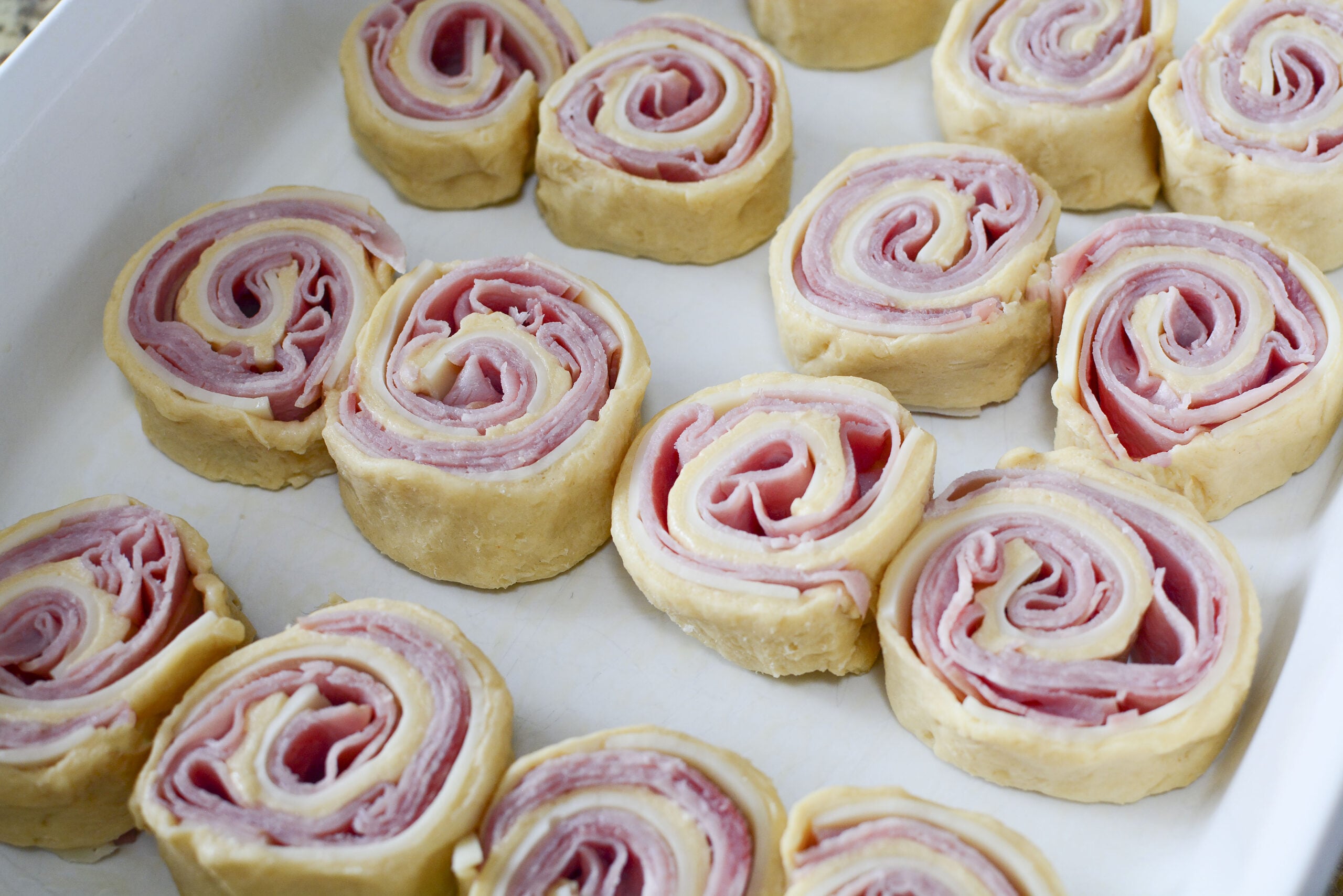 Ham and Cheese Pinwheels in a white baking dish unbaked