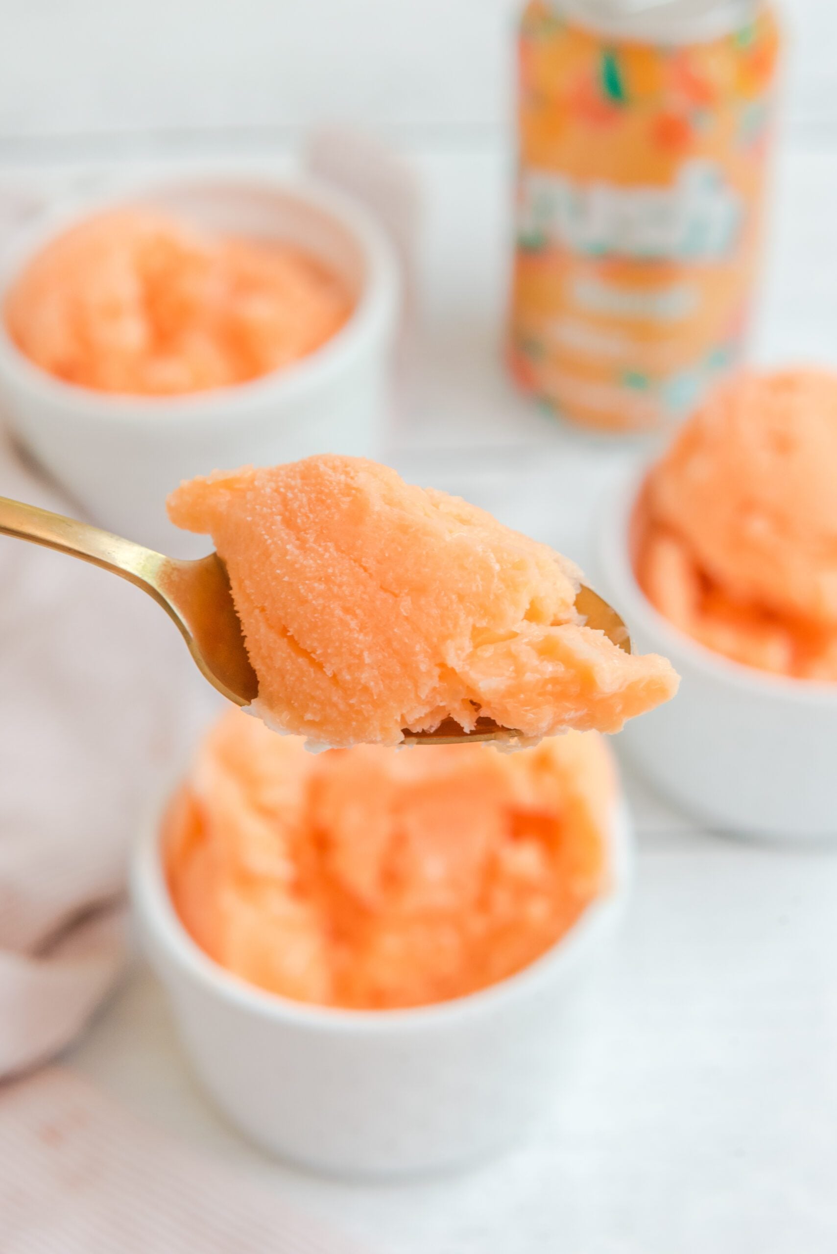 Orange Crush Sherbet on a gold spoon being lifted up