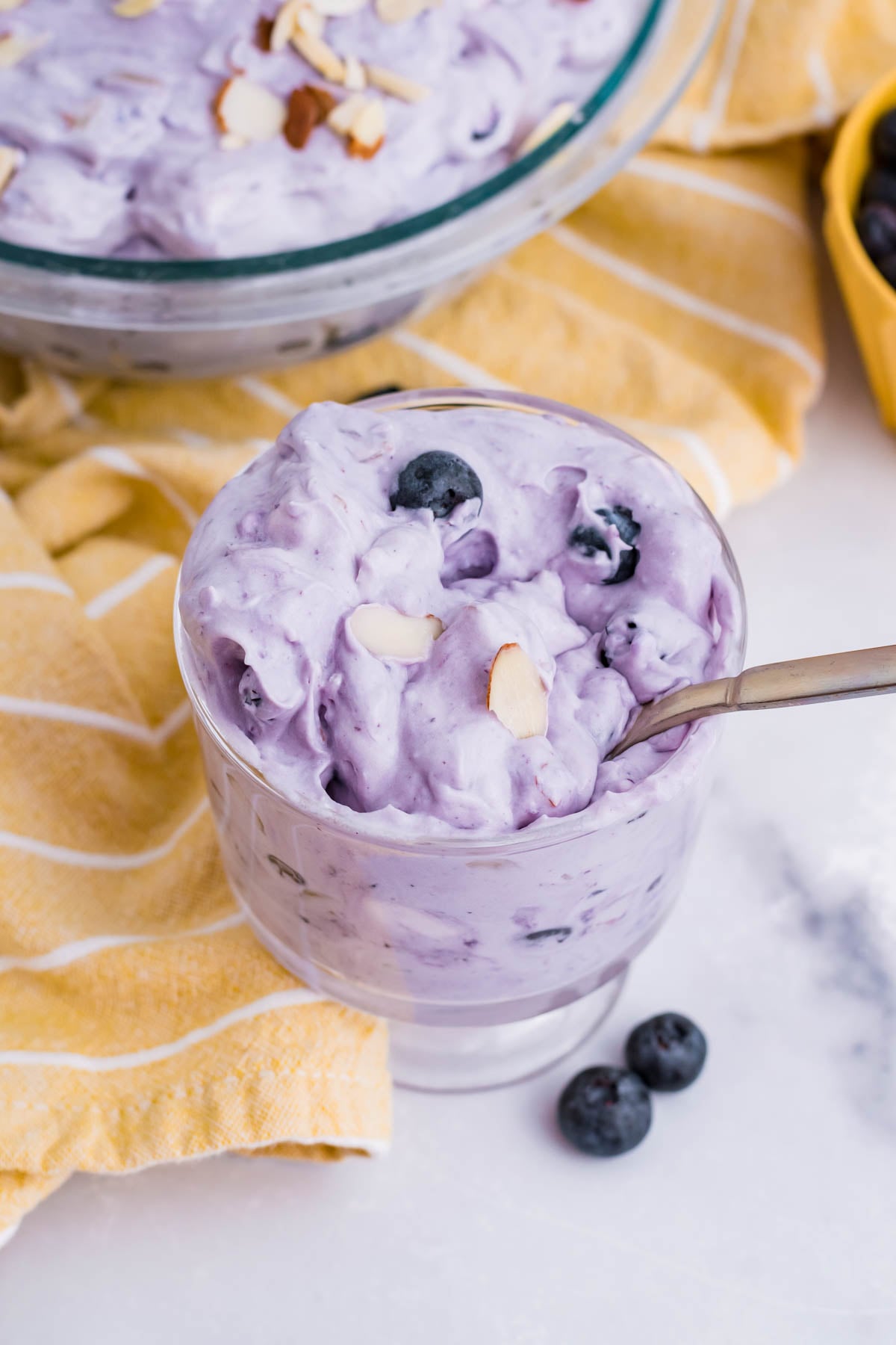 Blueberry Fluff Salad in a clear glass mini trifle with a spoon inside