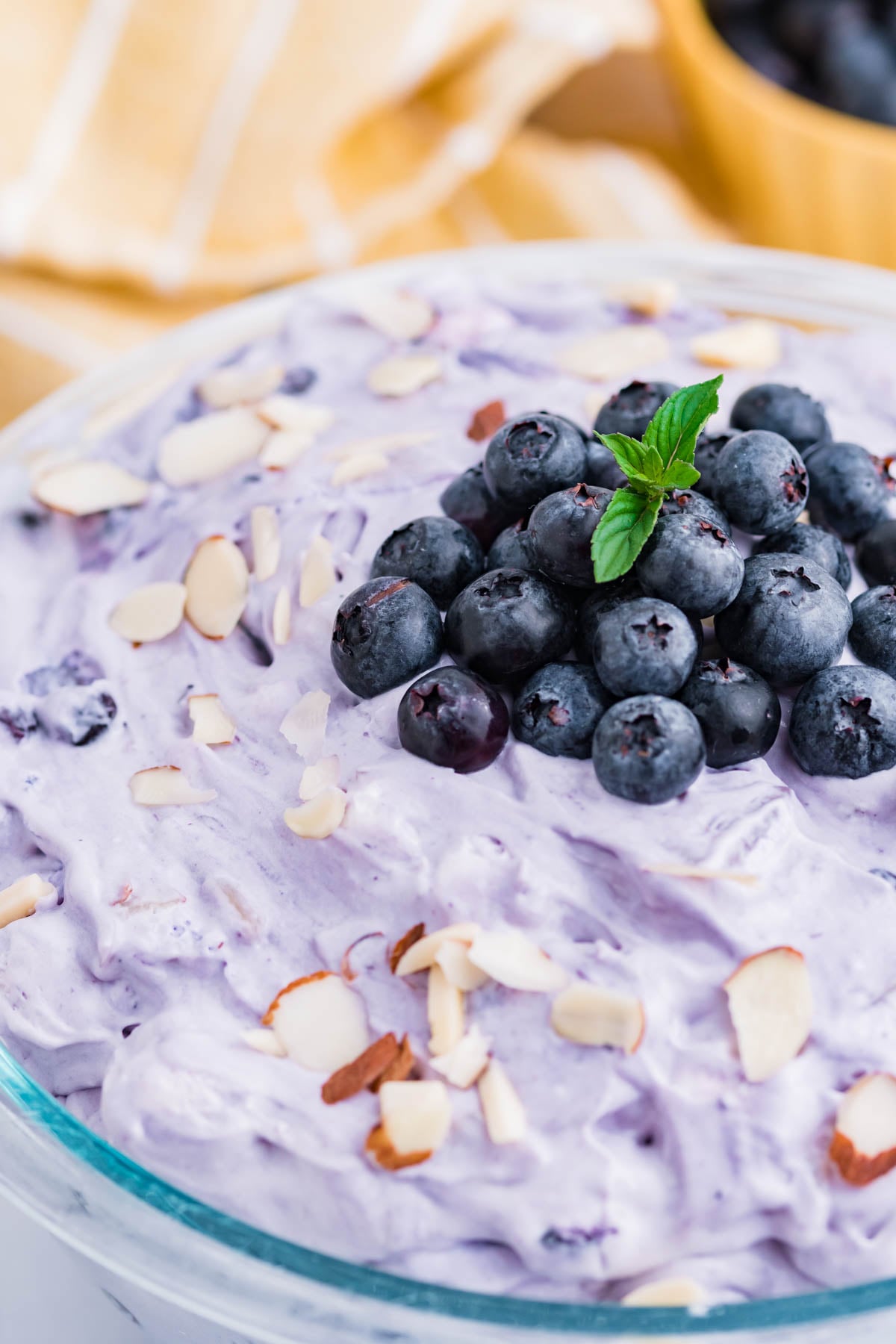 Blueberry Fluff Salad in a clear glass serving bowl close up of the fresh blueberries on top