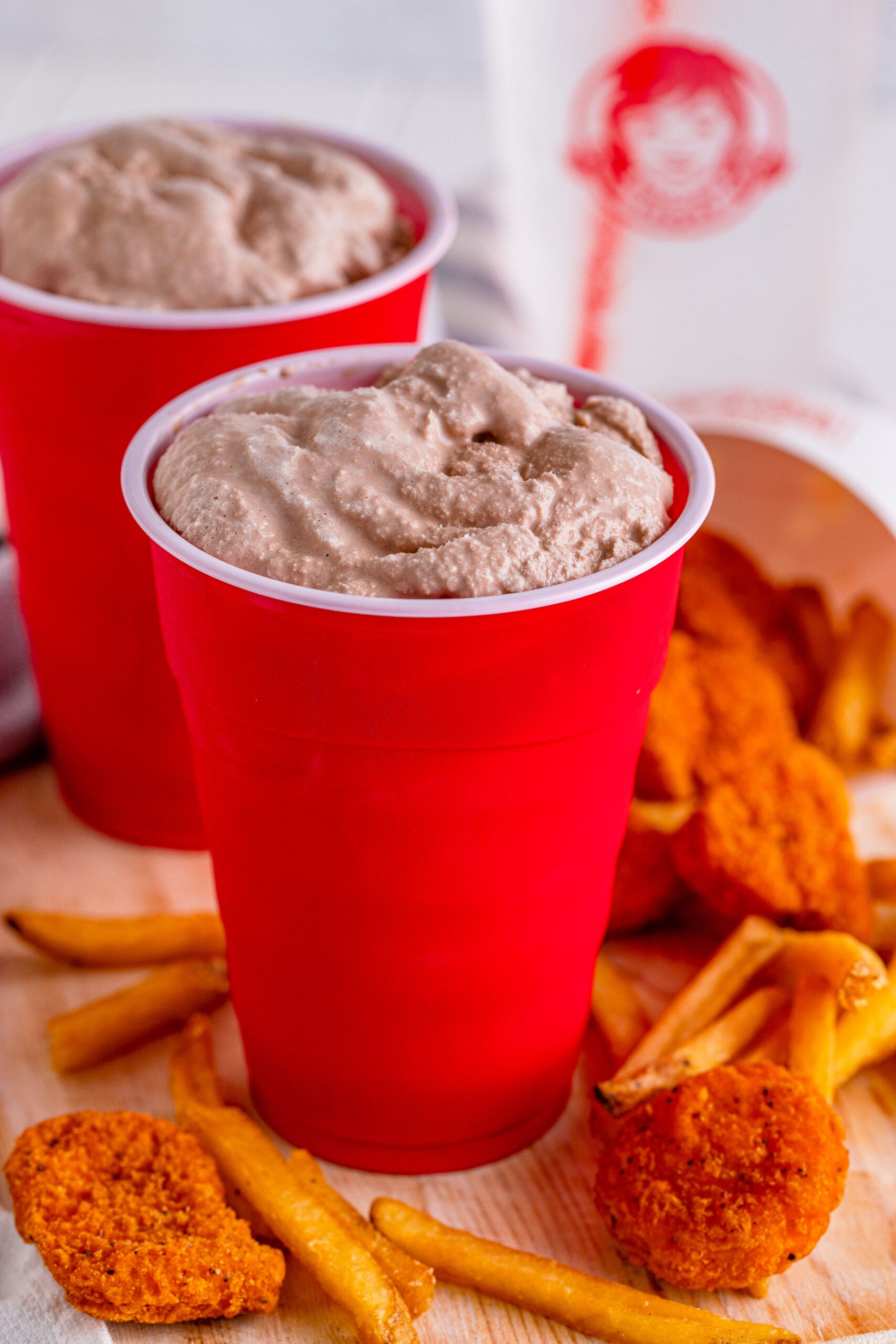 Wendys Frosty homemade in a red solo cup with fries and chicken nuggets next to the cup