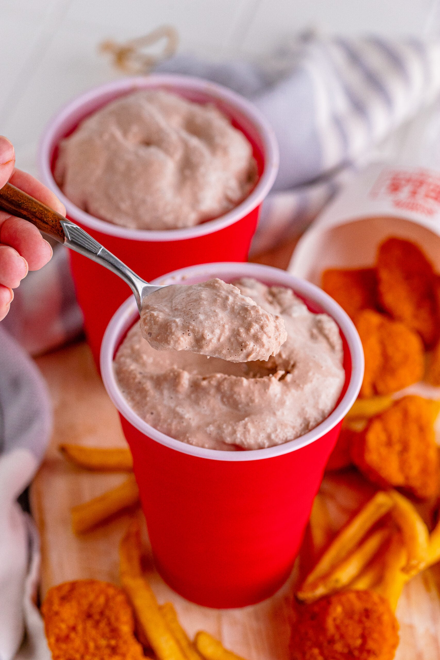 Wendys Frosty homemade in a red solo cup with a spoon scooping some out