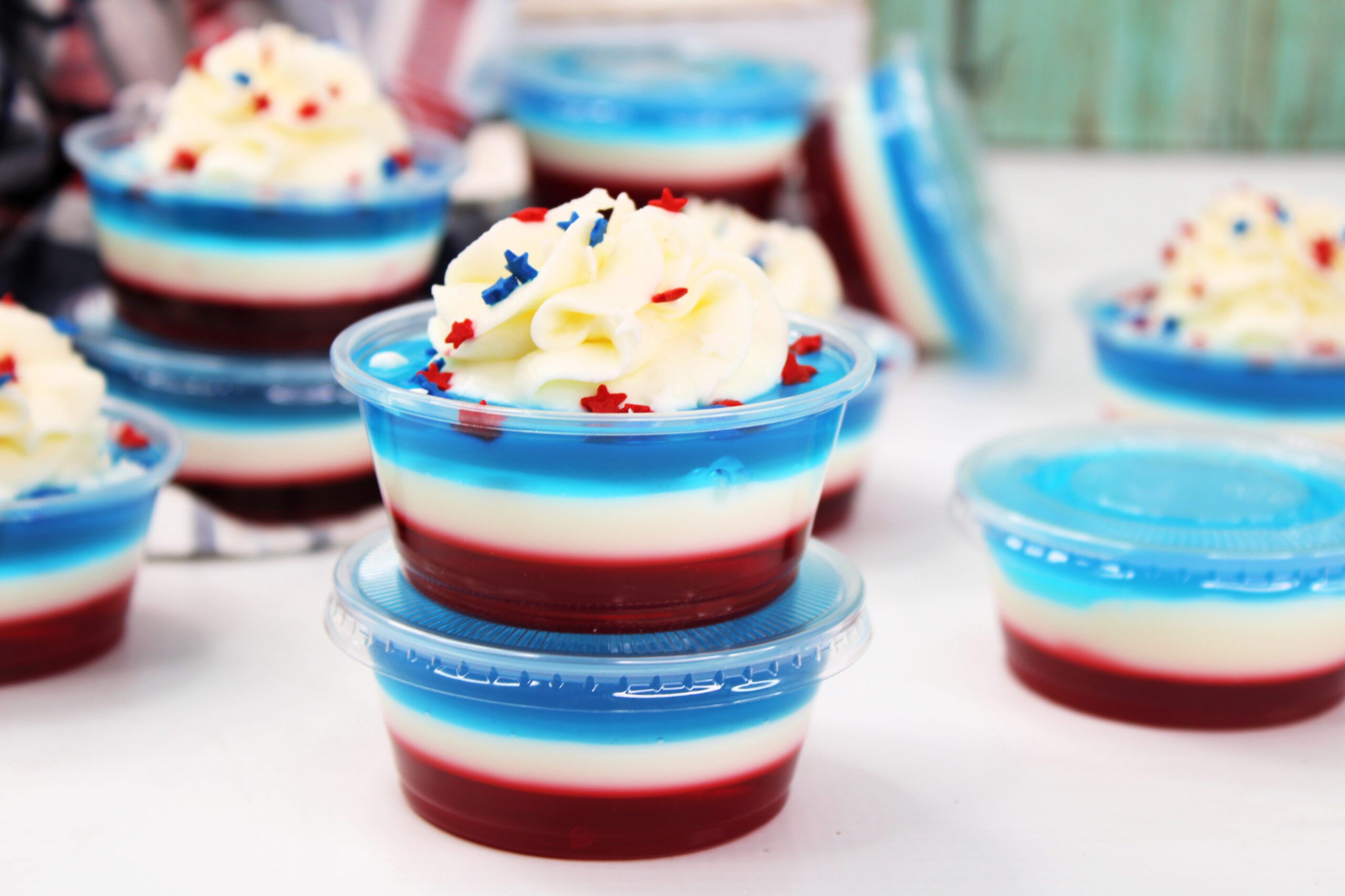 Bomb Pop Jello Shot layered red, white & blue topped with whipped cream and sprinkles