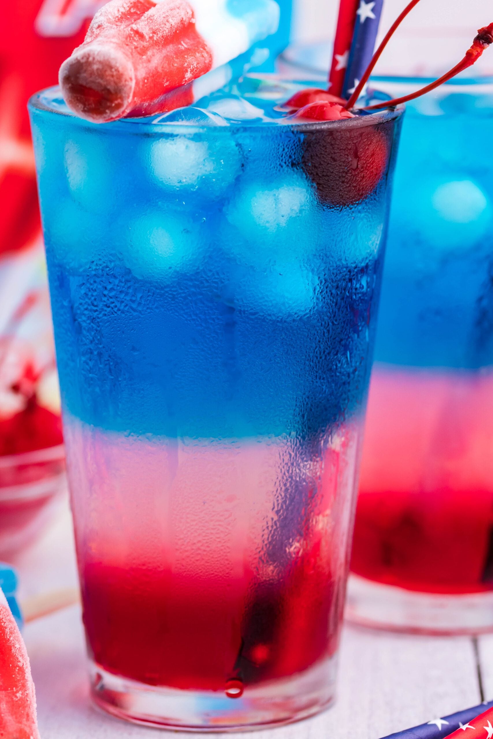Bomb Pop Cocktail Drink in a clear glass with a blue straw