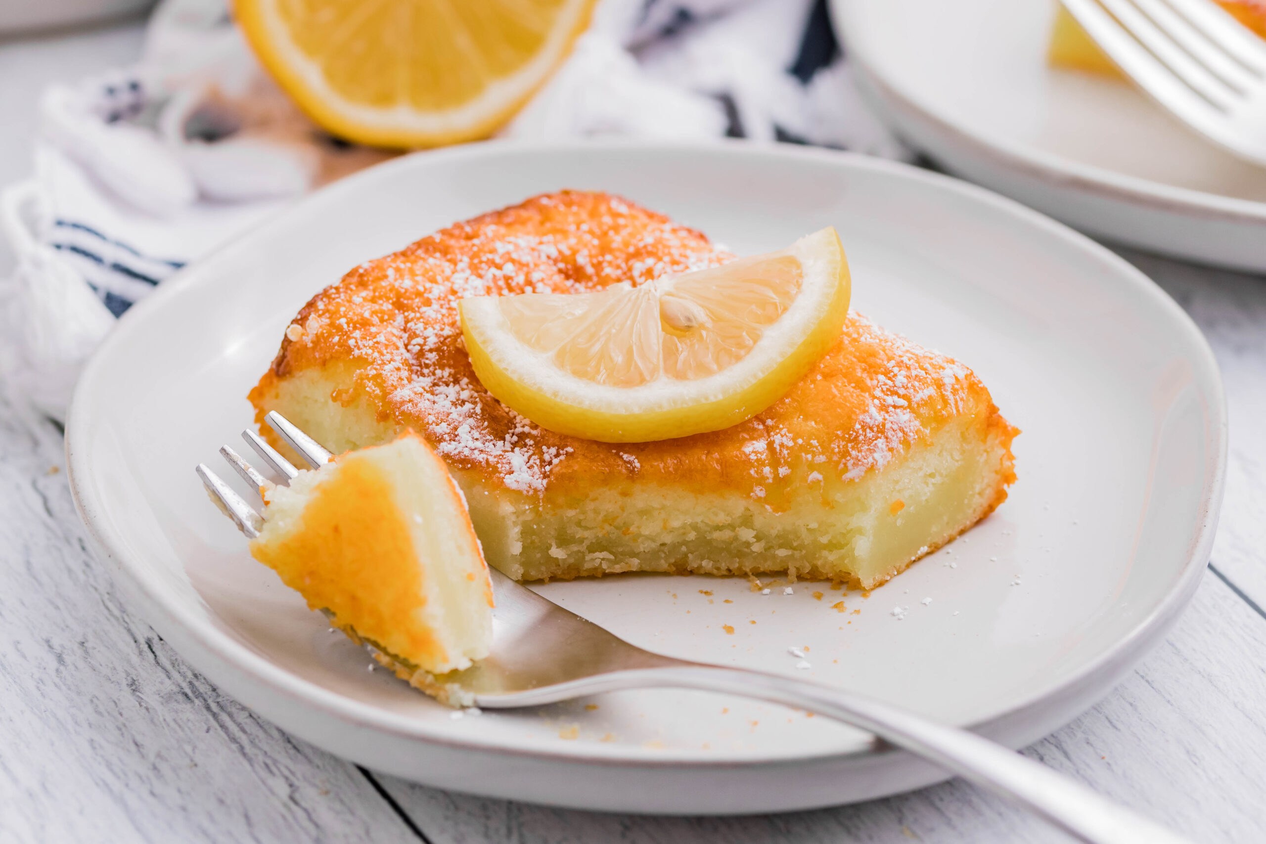 2 Ingredient Lemon Bars on a white plate with a fork taking a bite out