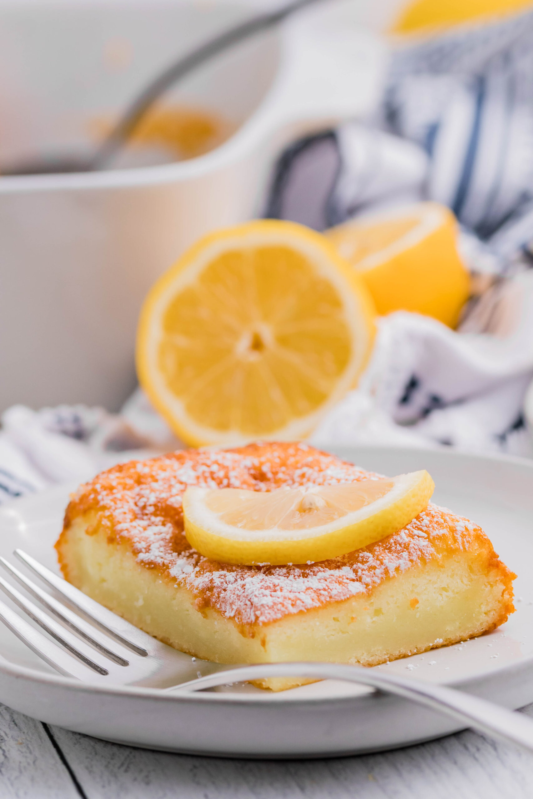 2 Ingredient Lemon Bar slice on a white plate with powdered sugar on top