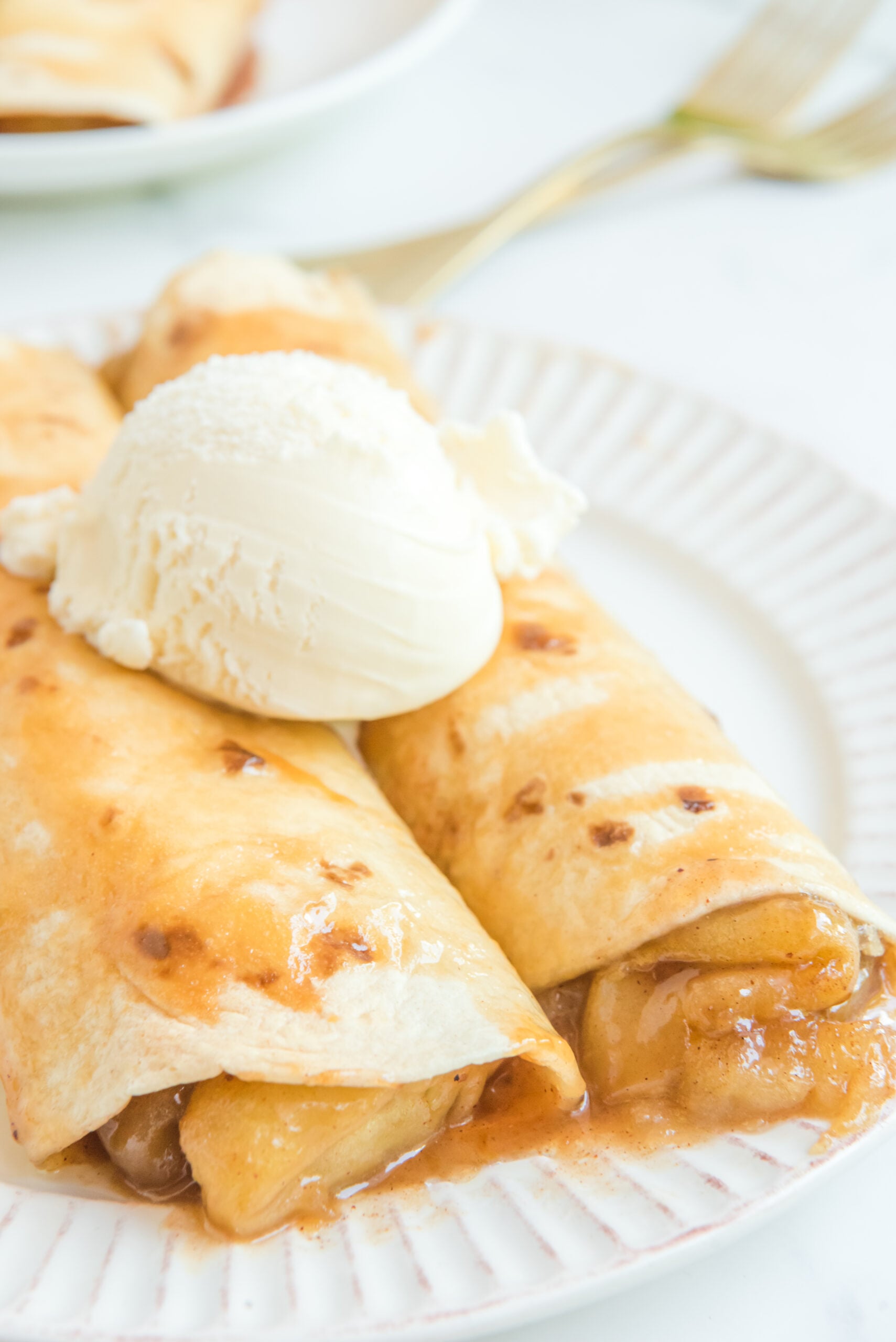 Apple Pie Enchiladas topped with vanilla ice cream