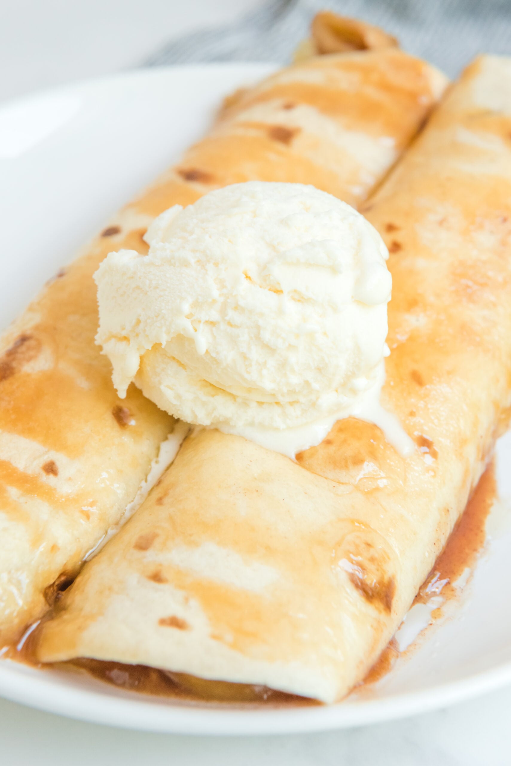 Apple Pie Enchiladas topped with vanilla ice cream overhead shot
