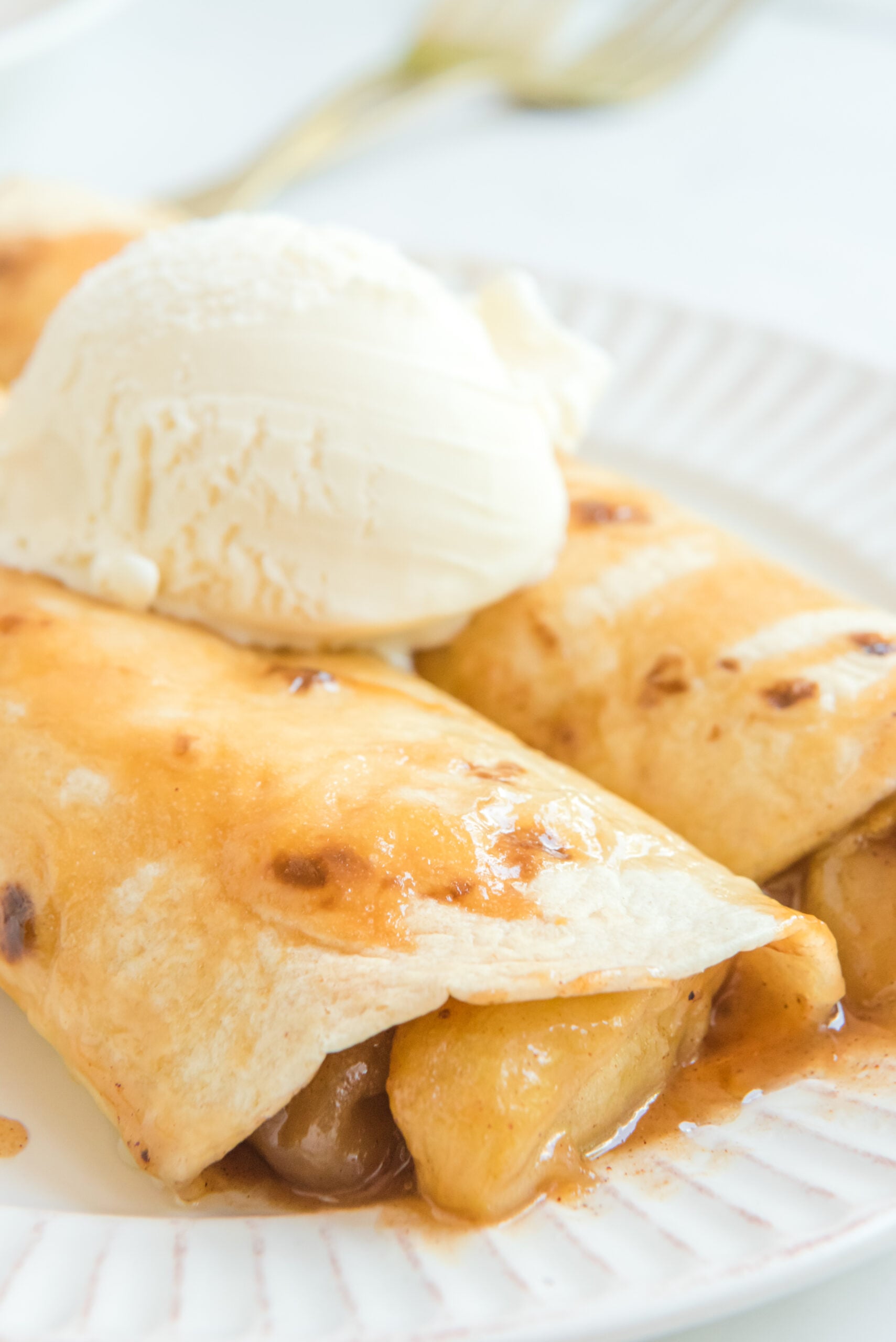 Apple Pie Enchiladas topped with vanilla ice cream close up