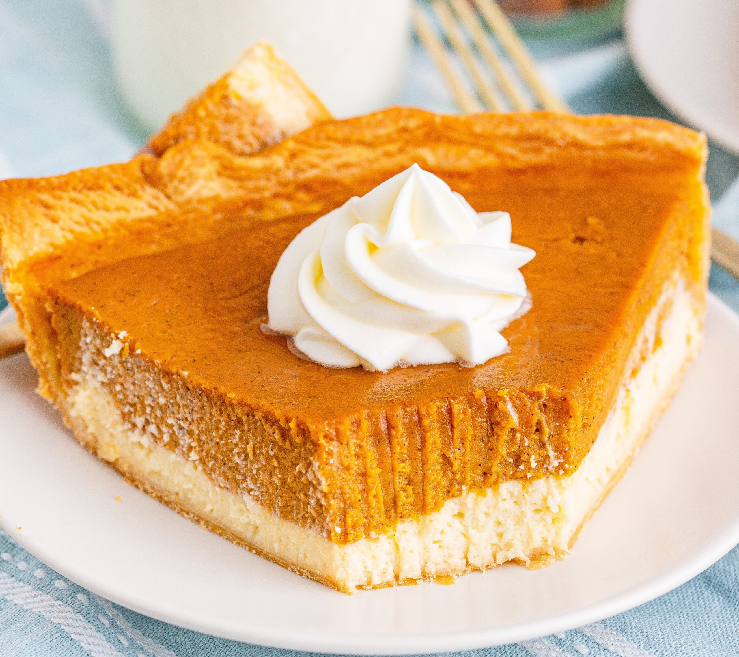 Pumpkin Pie Cheesecake slice on a white plate with a bite gone