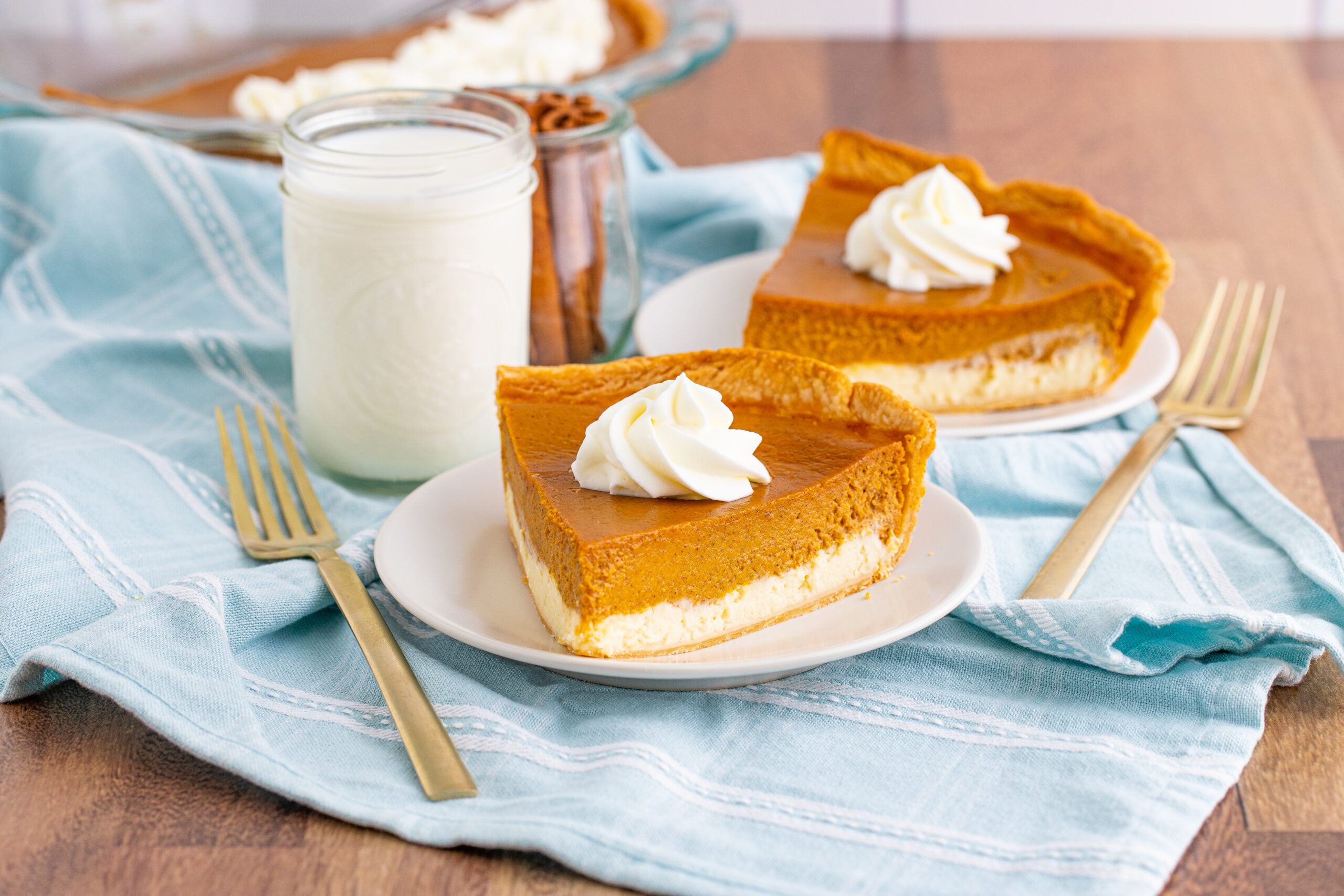 Pumpkin Pie Cheesecake slices on two white plates far away shot