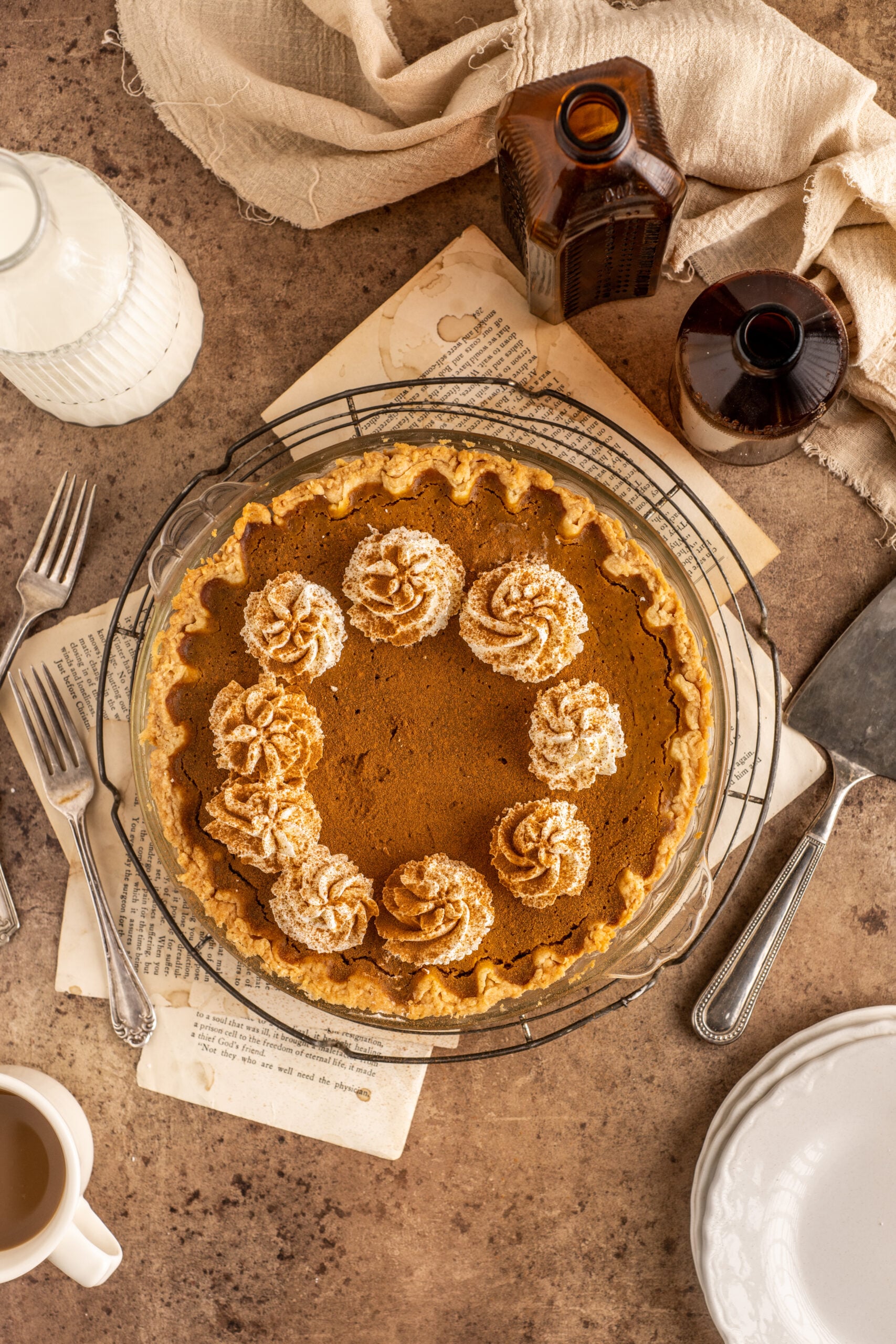 Pumpkin Custard Pie topped with whipped cream in a clear pie dish