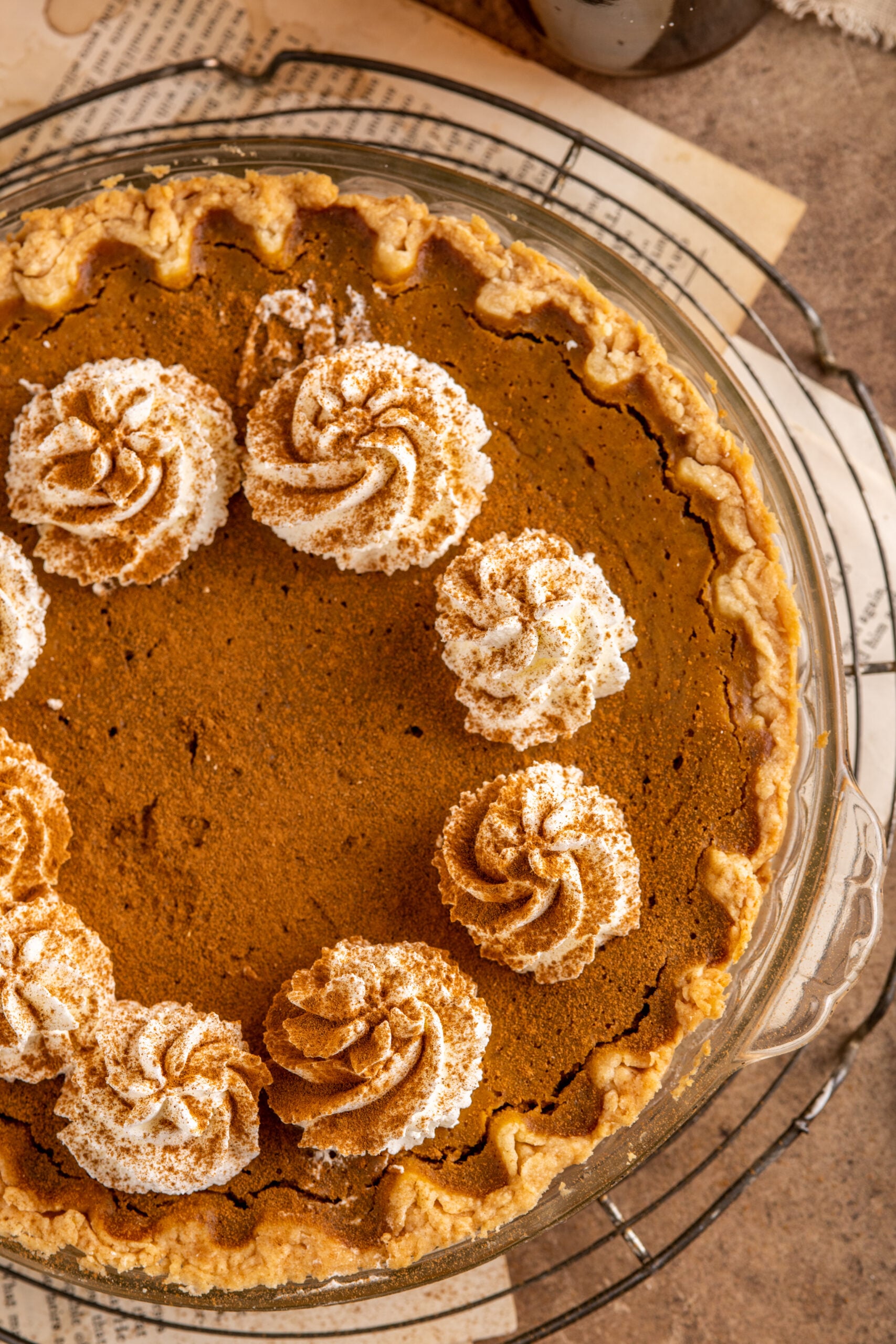 Pumpkin Custard Pie in a pie dish topped with cinnamon and whipped cream