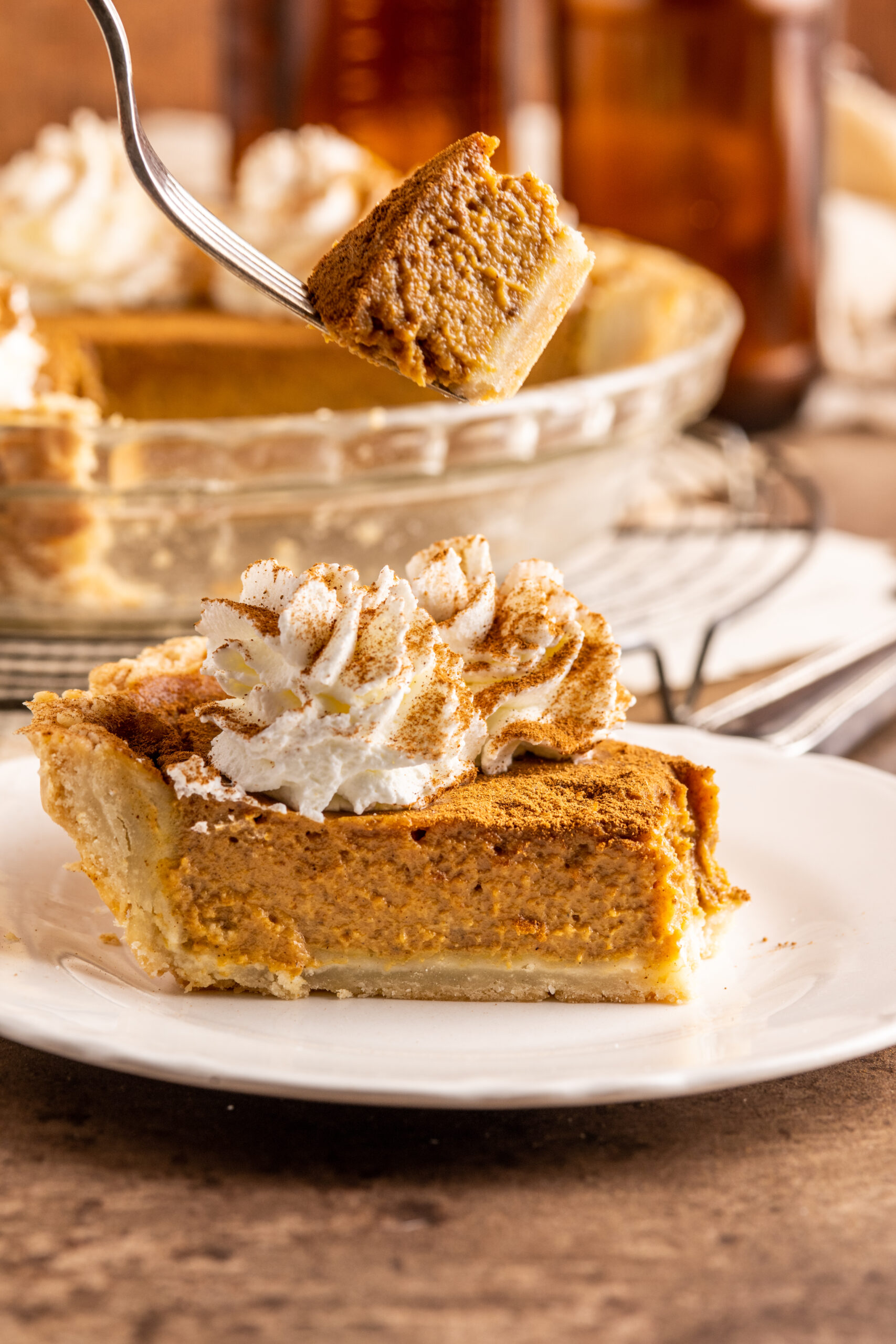 Pumpkin Custard Pie slice with a fork lifting up a bite