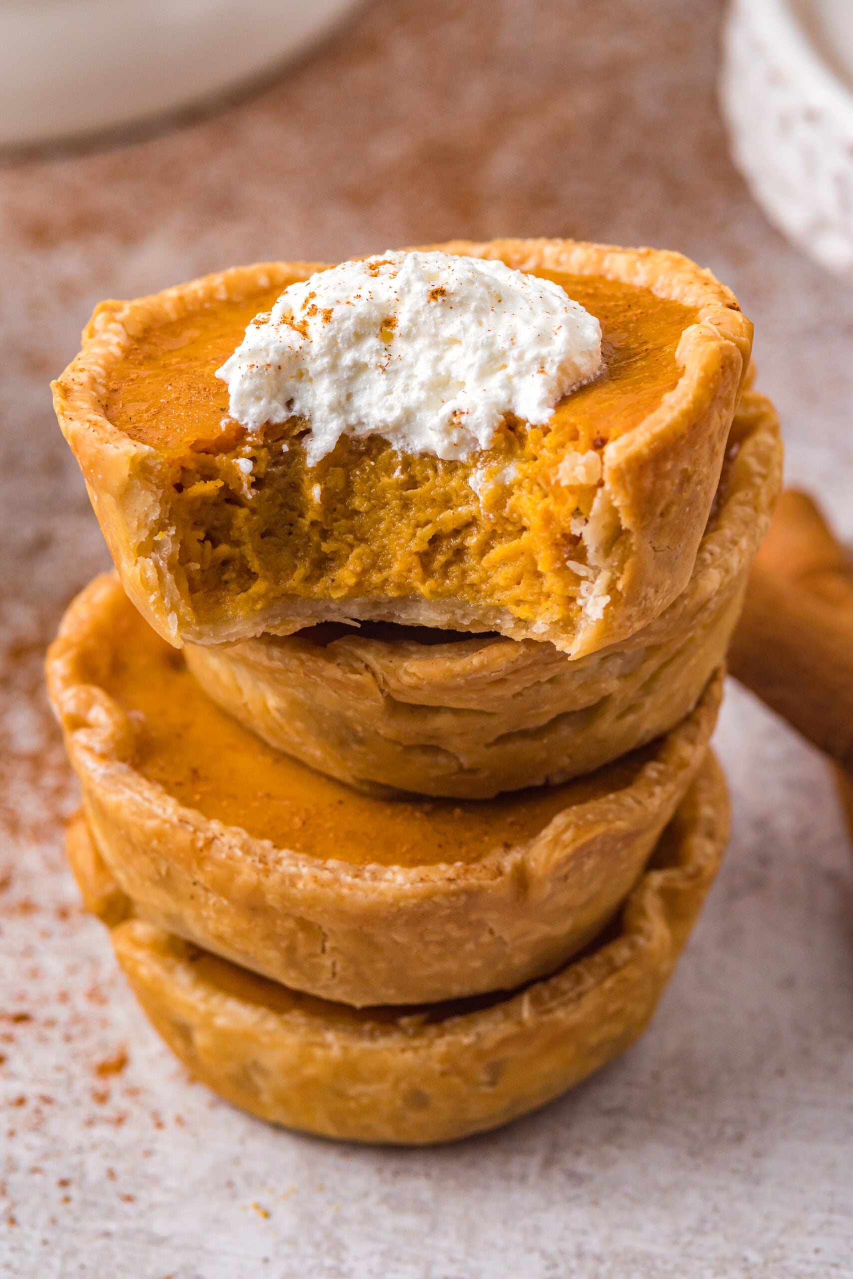 Stack of mini pumpkin pies with a bite missing