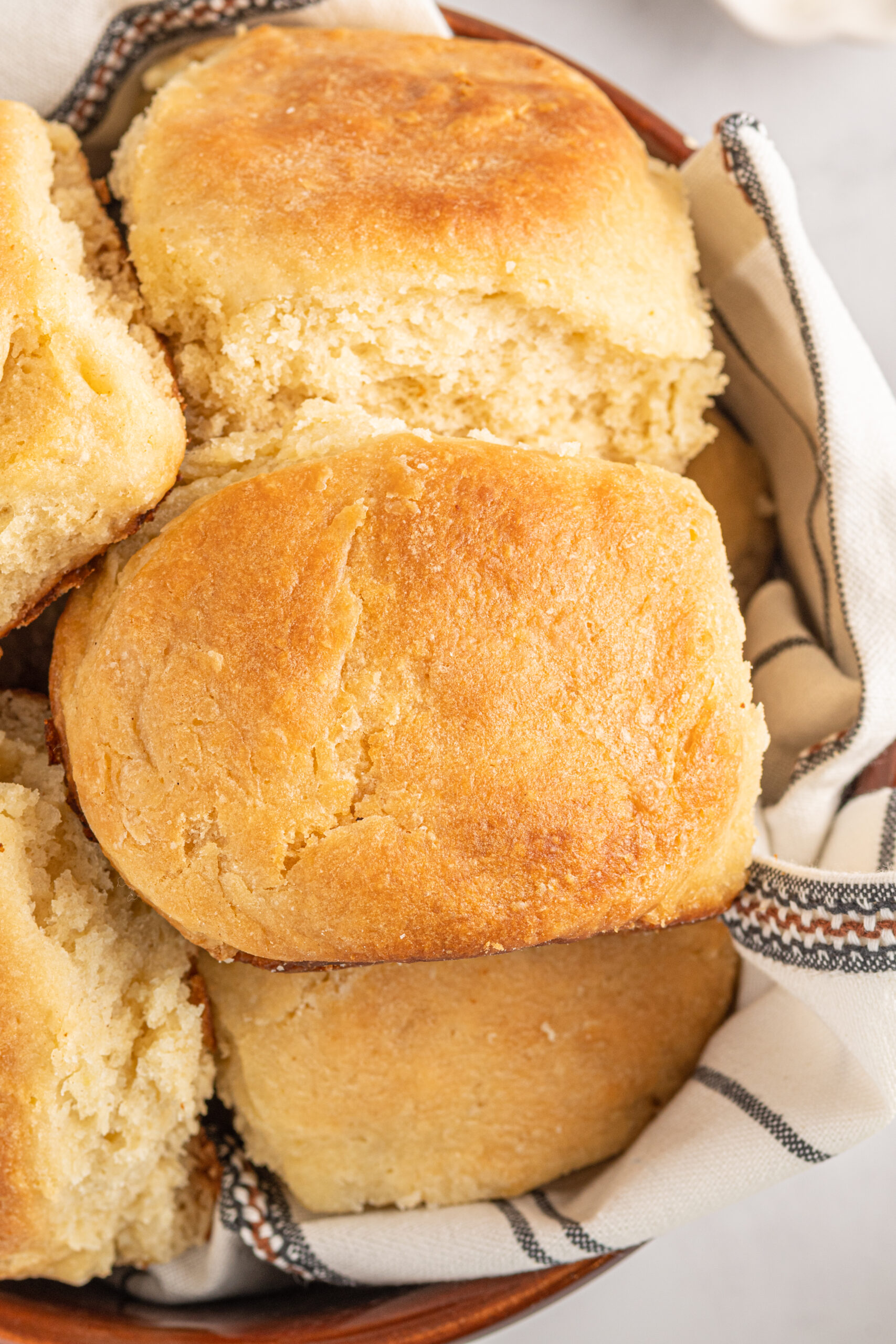 Close up of Angel Biscuits in a brown bowl with a white and black linen.