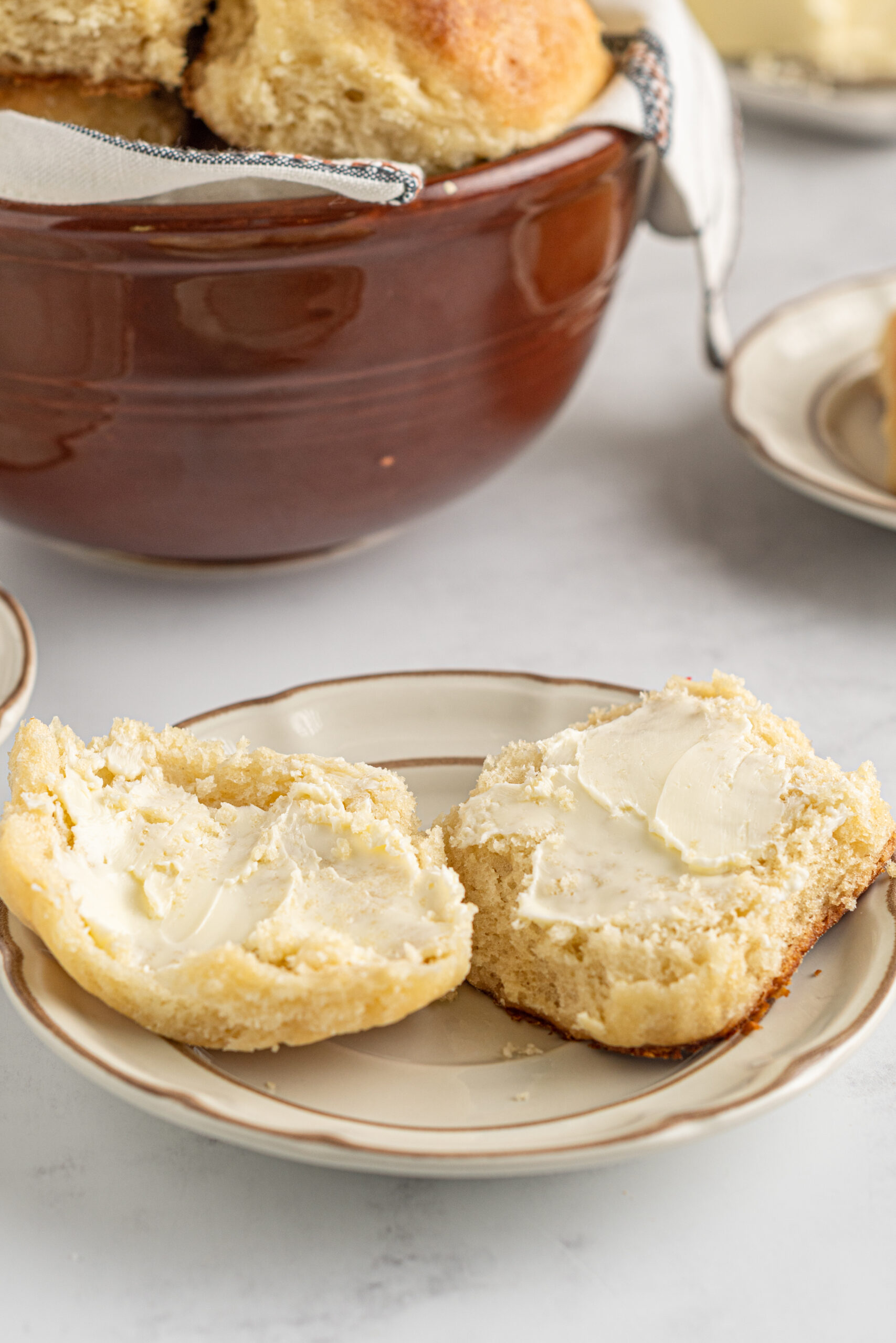 A biscuit cut in half showing the fluffy center topped with butter.