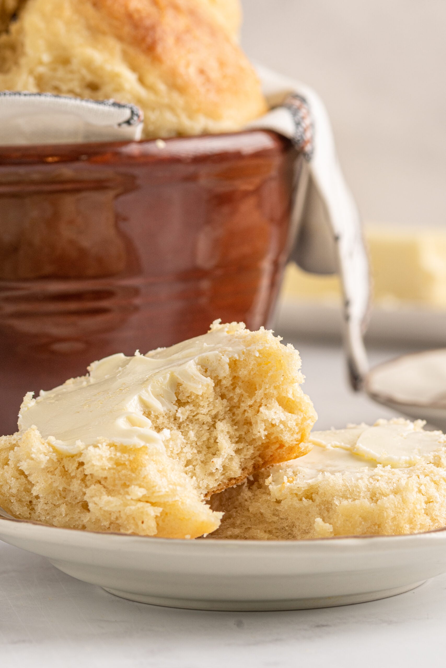 A biscuit cut in half showing the fluffy center topped with butter.