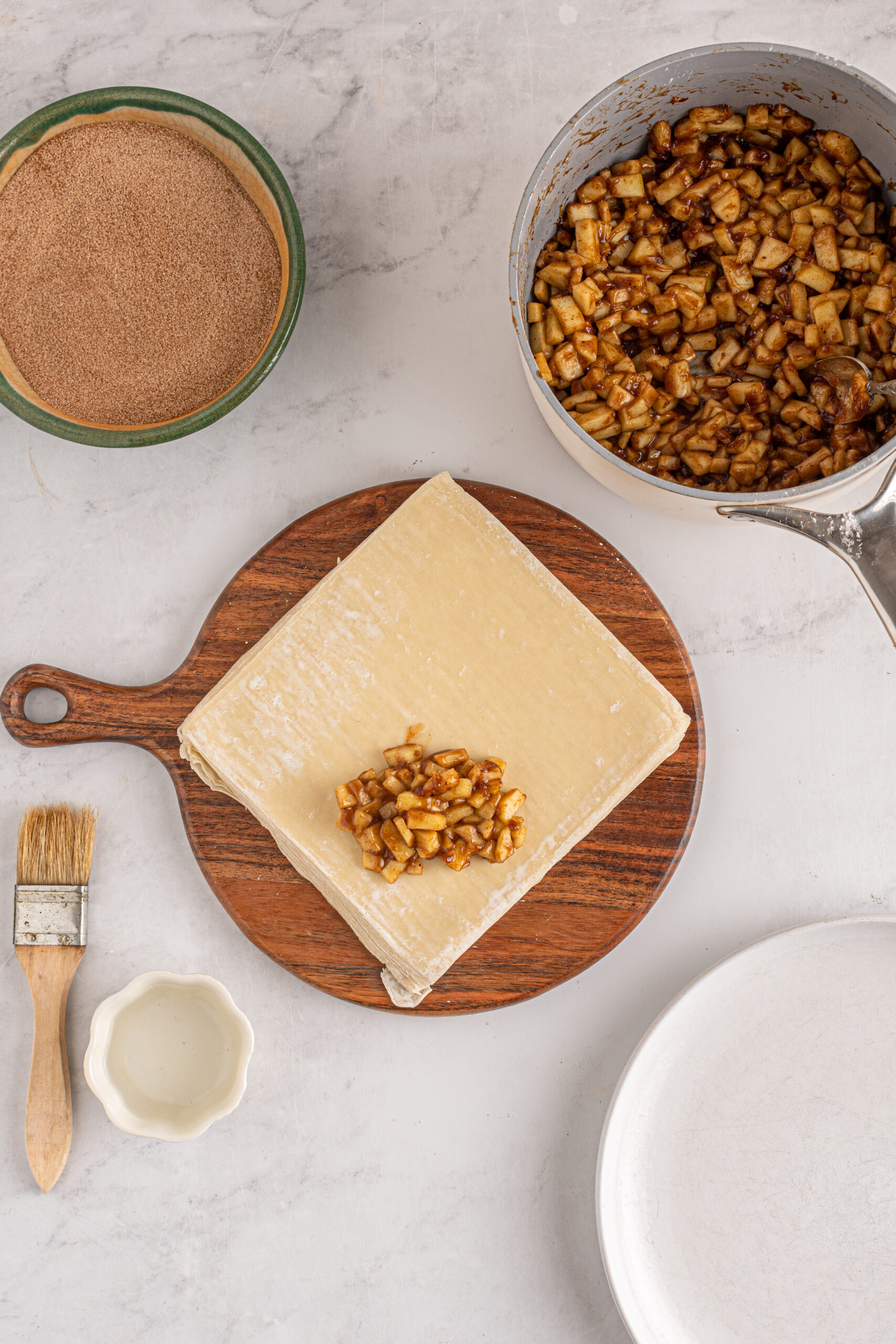Overhead view of wrapping apple pie egg rolls.