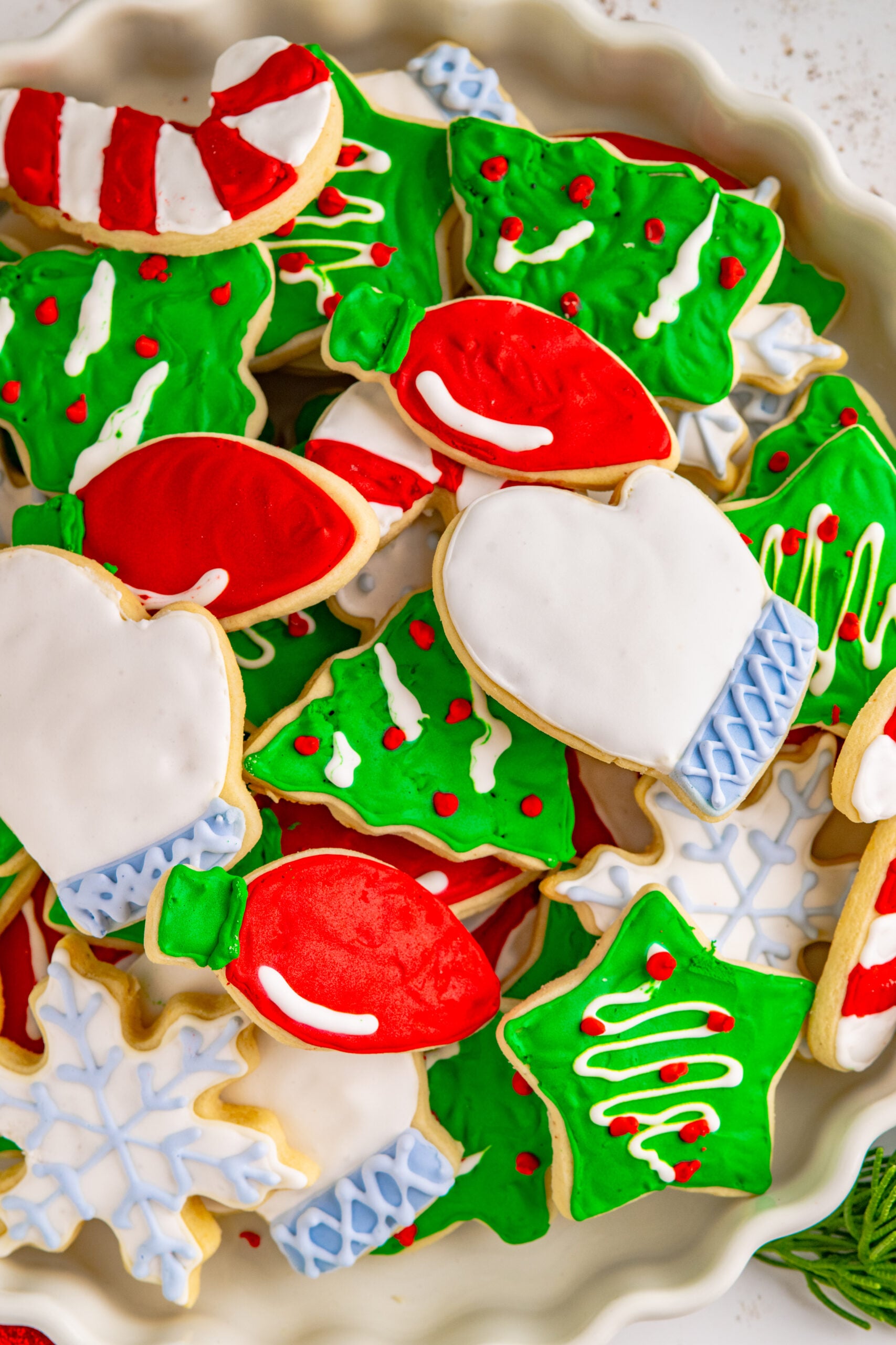 Christmas Sugar Cookies stacked on a white serving tray.
