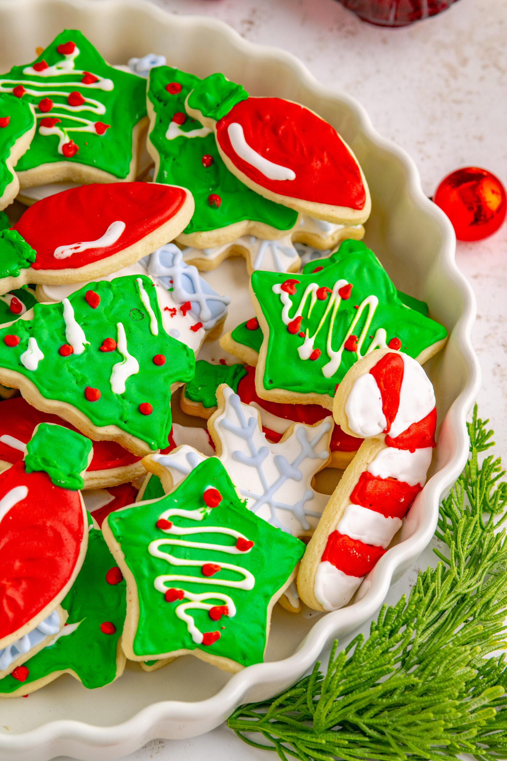 Christmas Sugar Cookies stacked on a white serving tray.