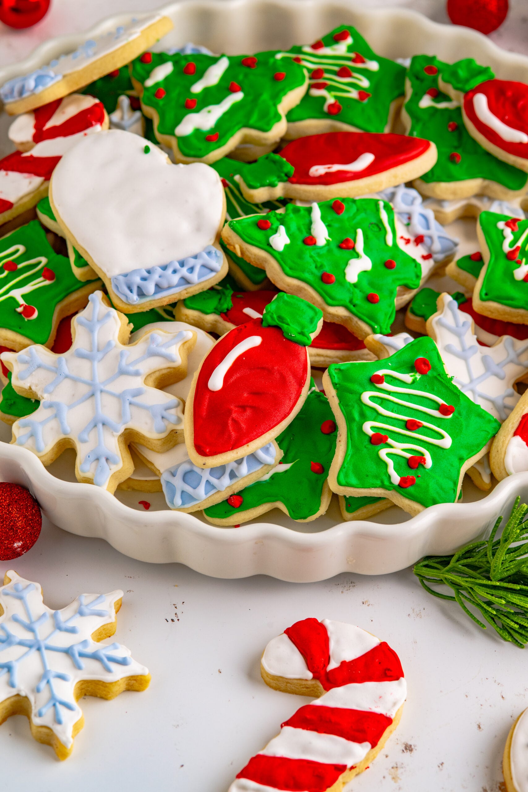 Christmas Sugar Cookies stacked on a white serving tray.