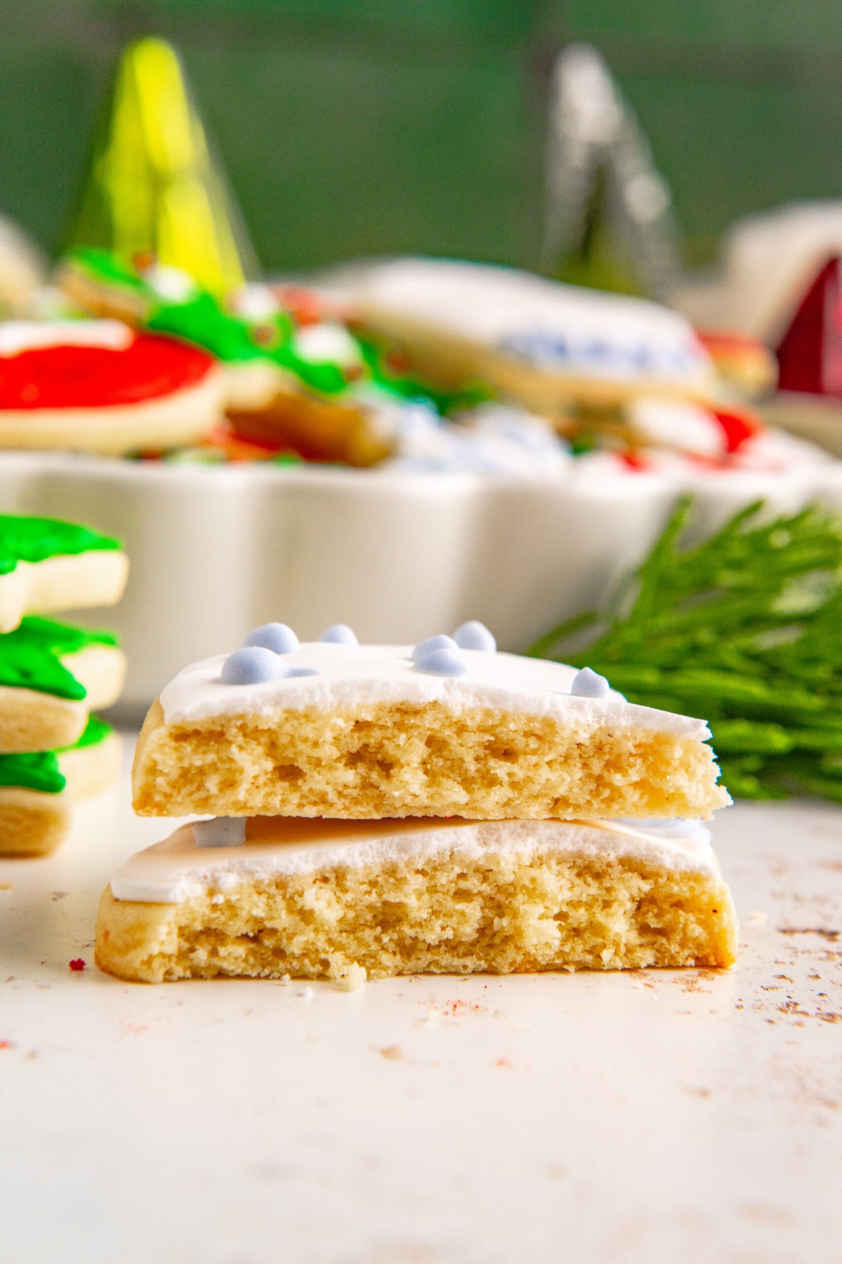 A Christmas Sugar Cookie cut in half showing the chewy inside.