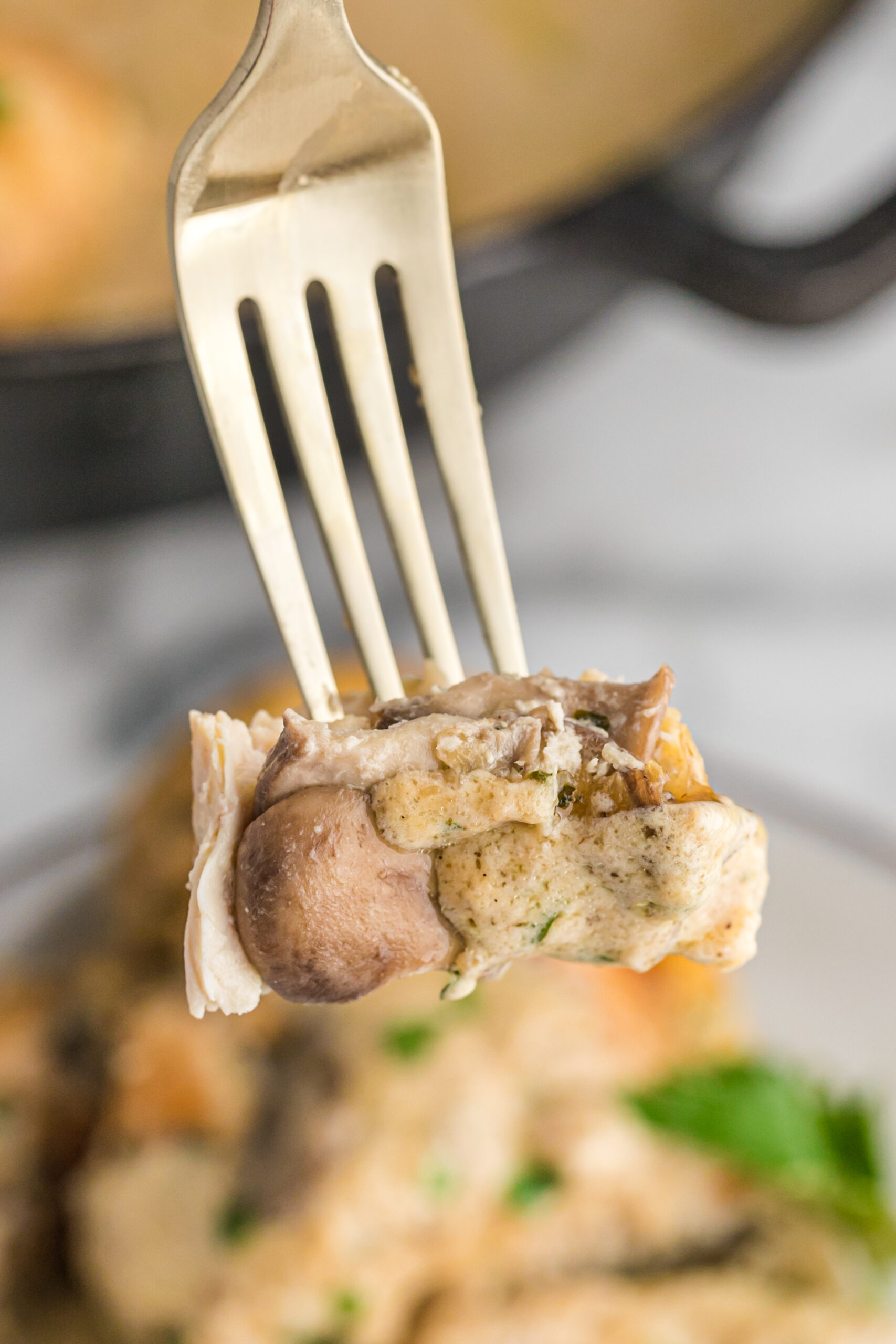 A close up shot of a piece of cheesy Garlic Butter Mushroom Stuffed Chicken 