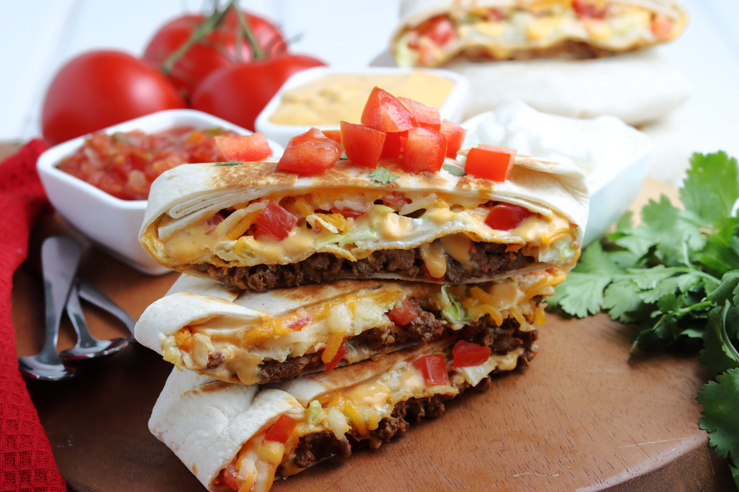 Three crunch wraps cut in half and stacked on top of each other showing the layers on the inside.