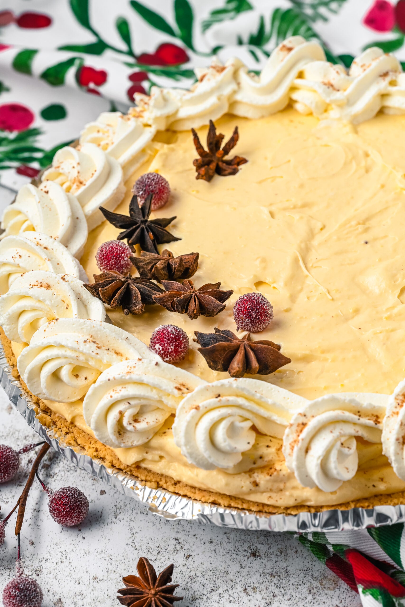45 degree angle of the full decorated Eggnog pie topped with sugared cranberries and star anise.
