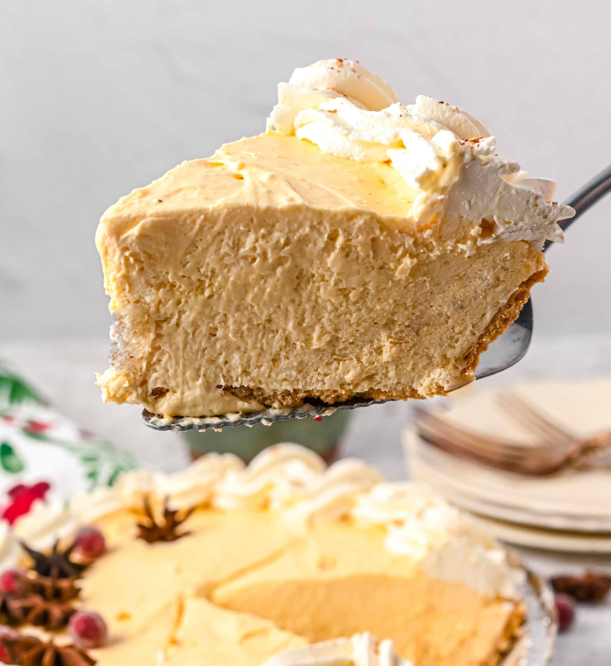 A slice of eggnog pie being lift up on a pie spatula.