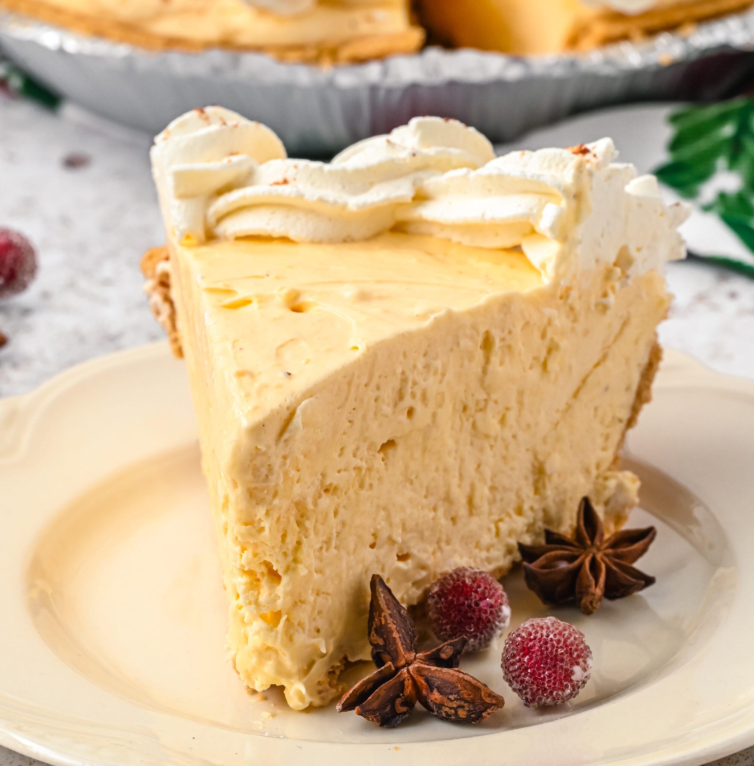 Close up of a slice of eggnog pie on a cream colored plate.