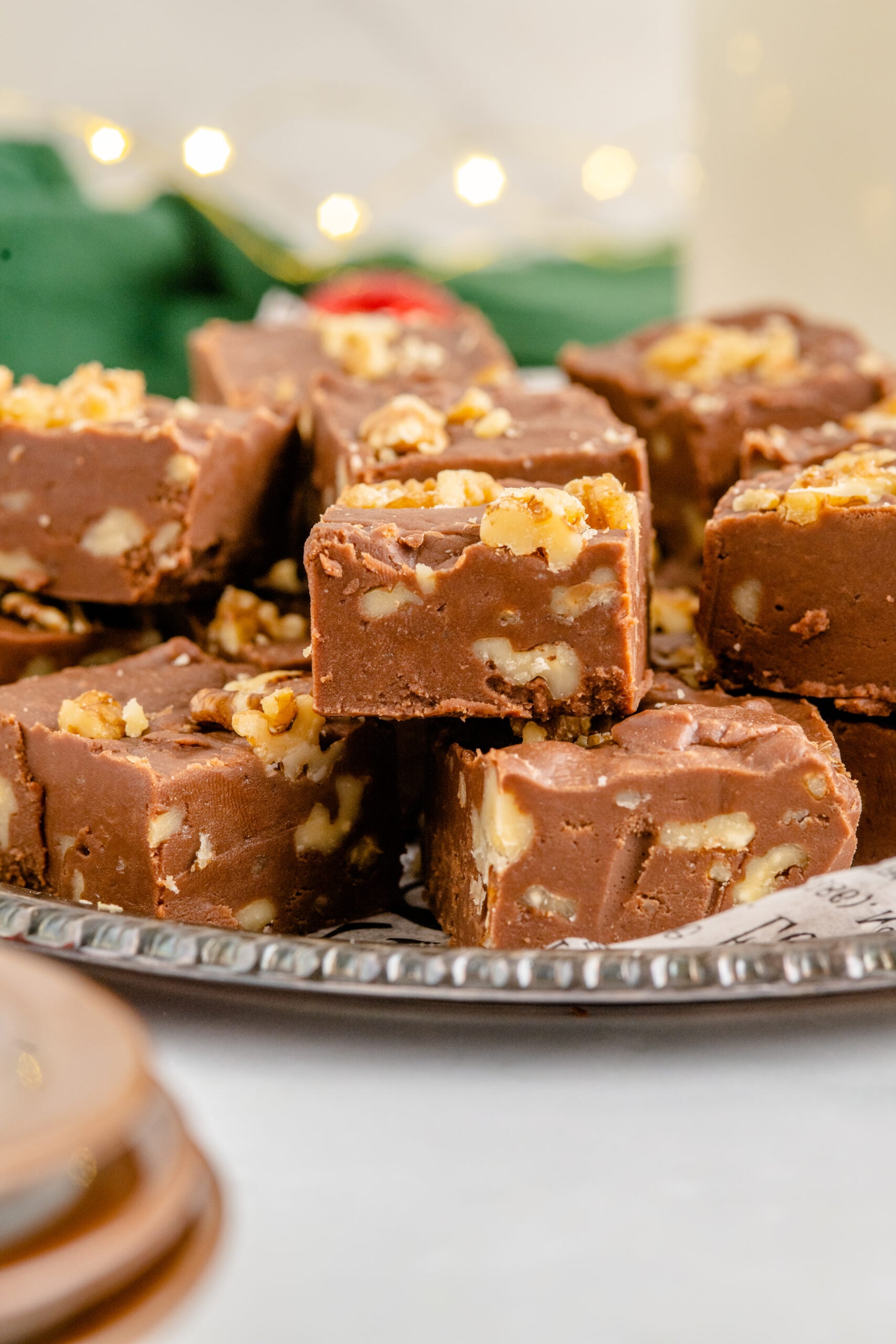 Fantasy Fudge stacked on a tin serving tray with twinkle lights in the background.