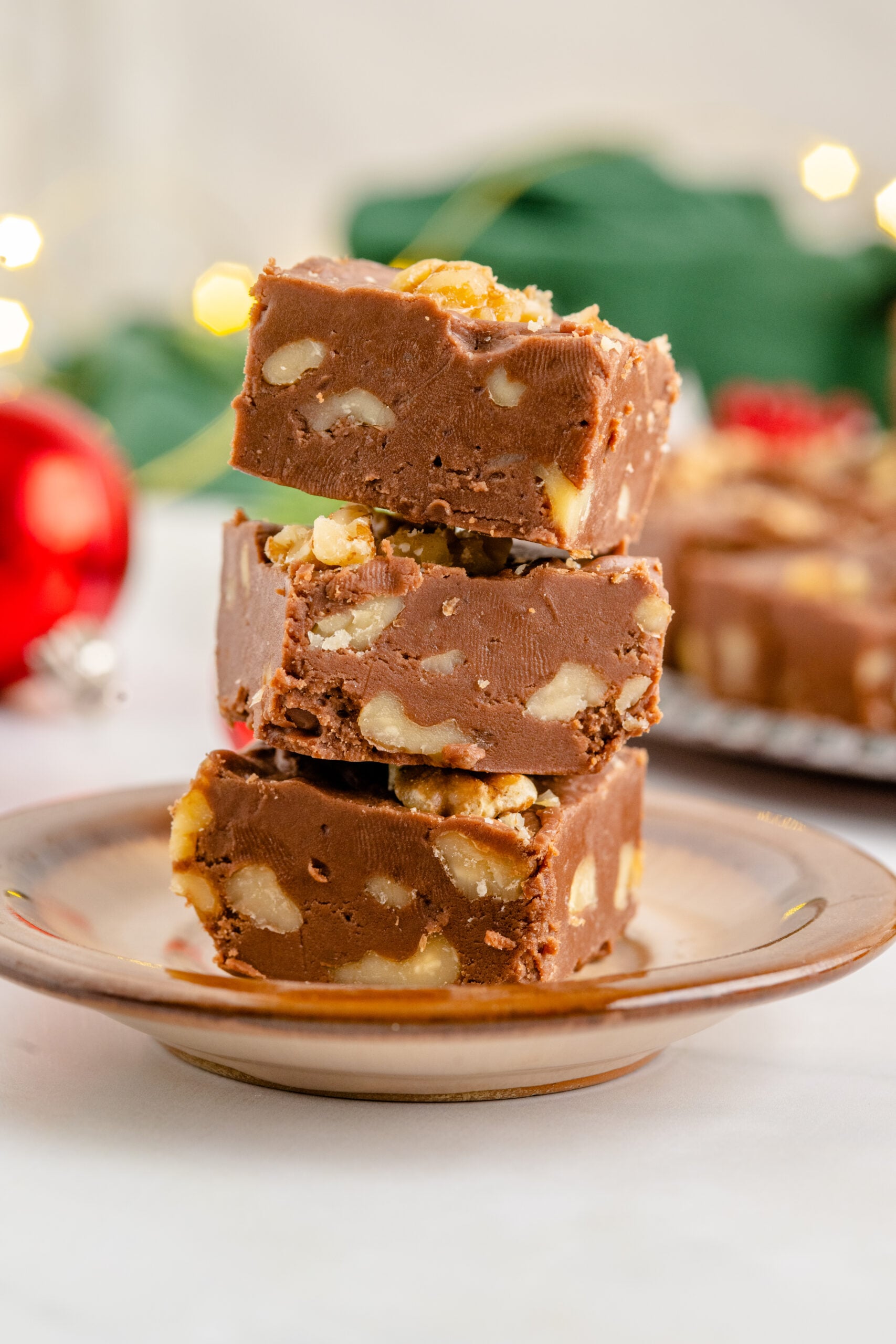 Three pieces of fudge stacked on a brown plate.