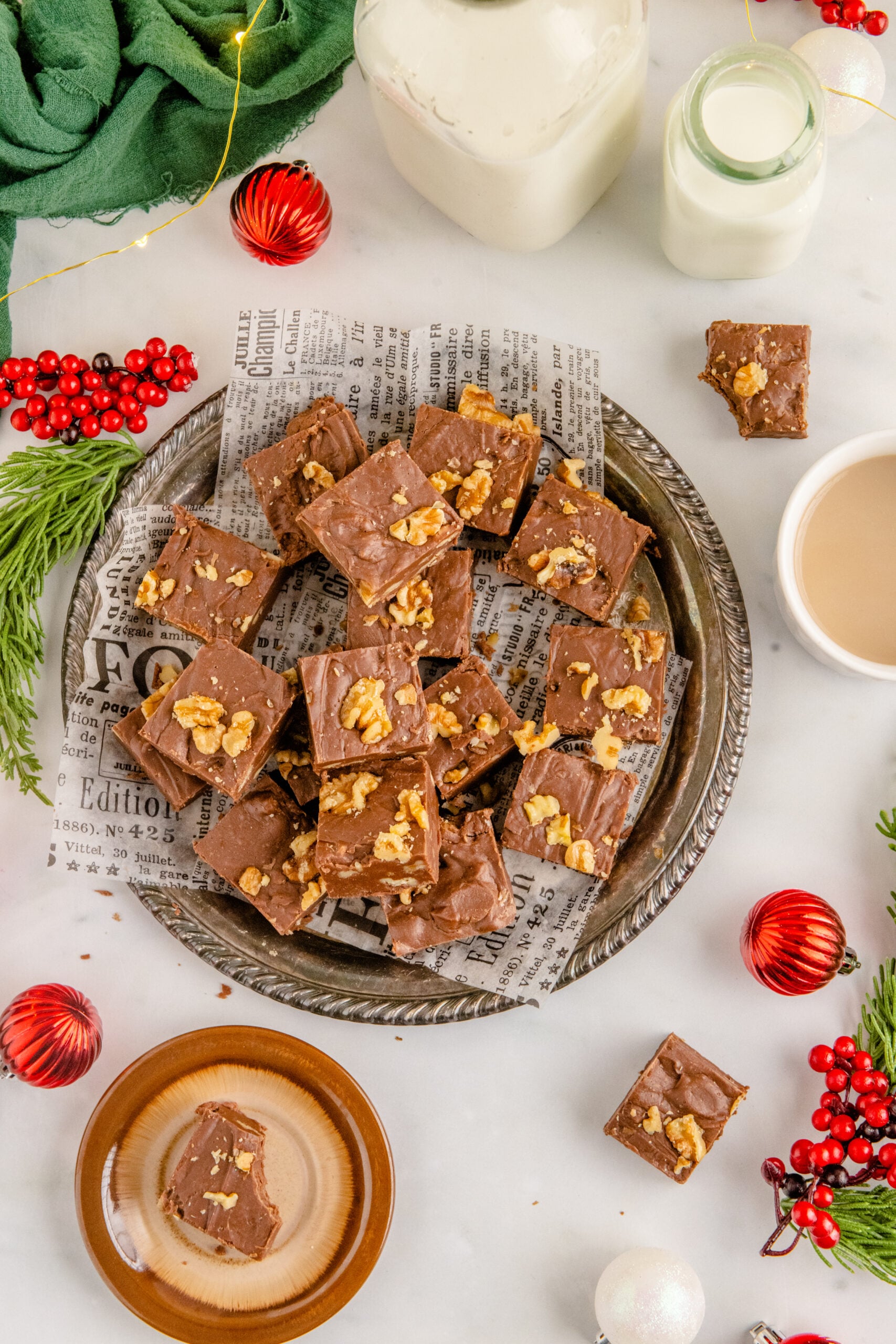 Overhead shot of the fudge stacked on a tin serving tray with holiday decorations in the background.