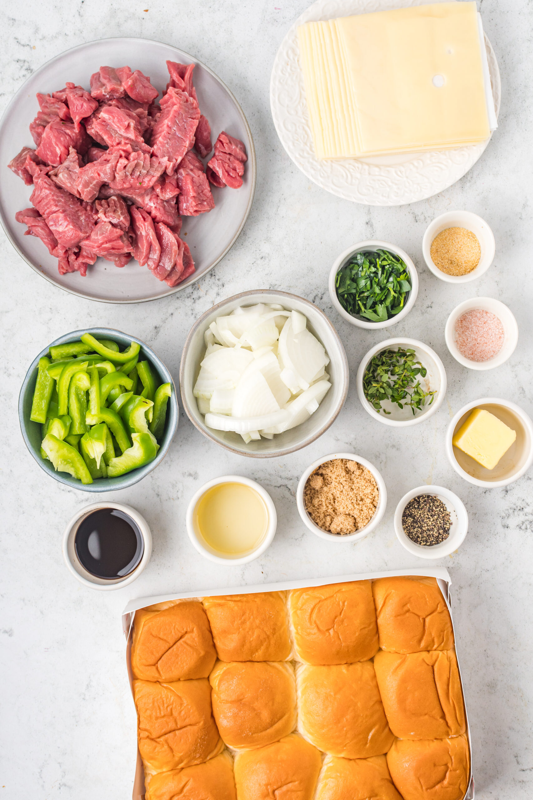 Overhead shot of ingredients needed to make Philly Cheesesteak Sliders. 