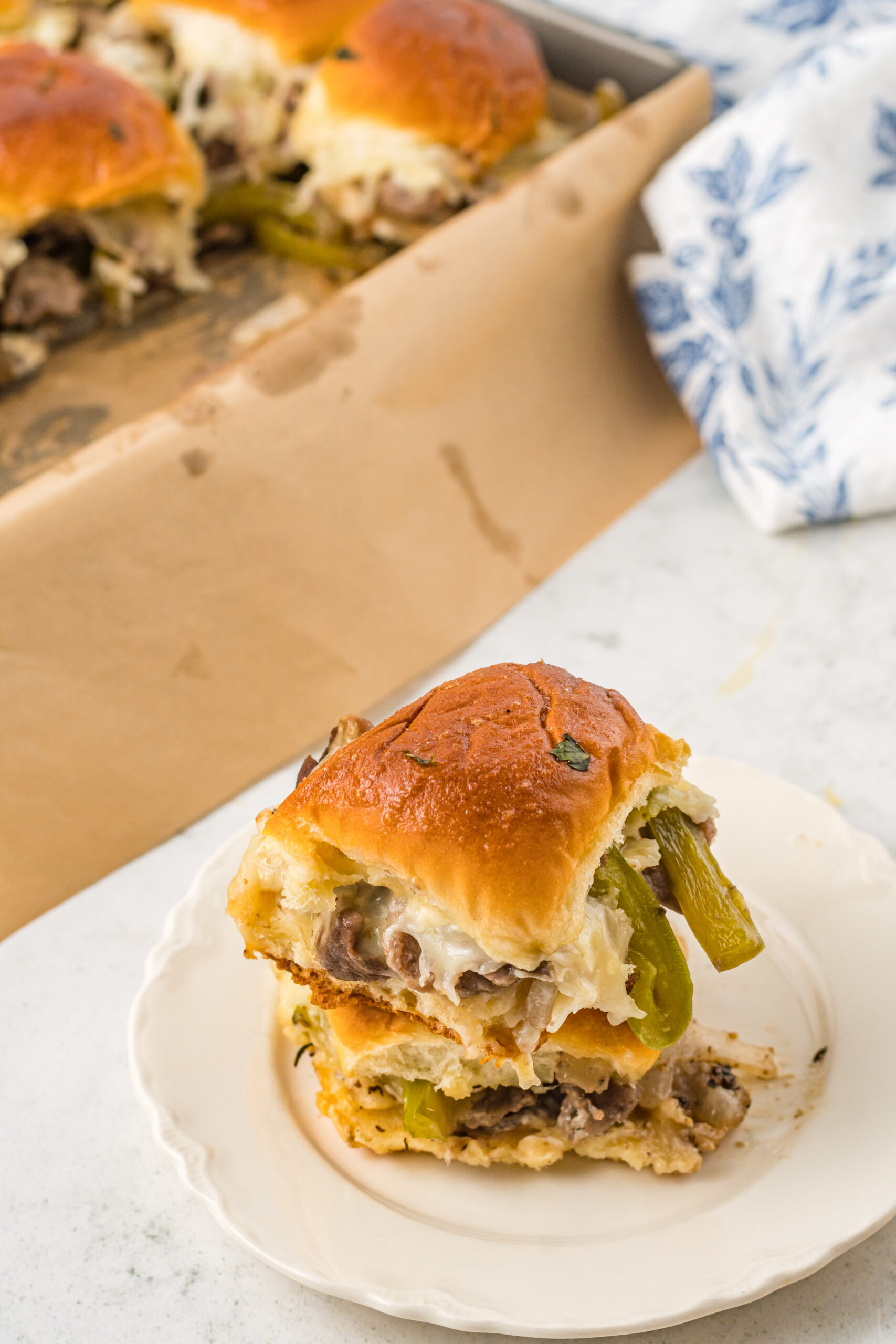 Two sliders stacked on a white plate. 