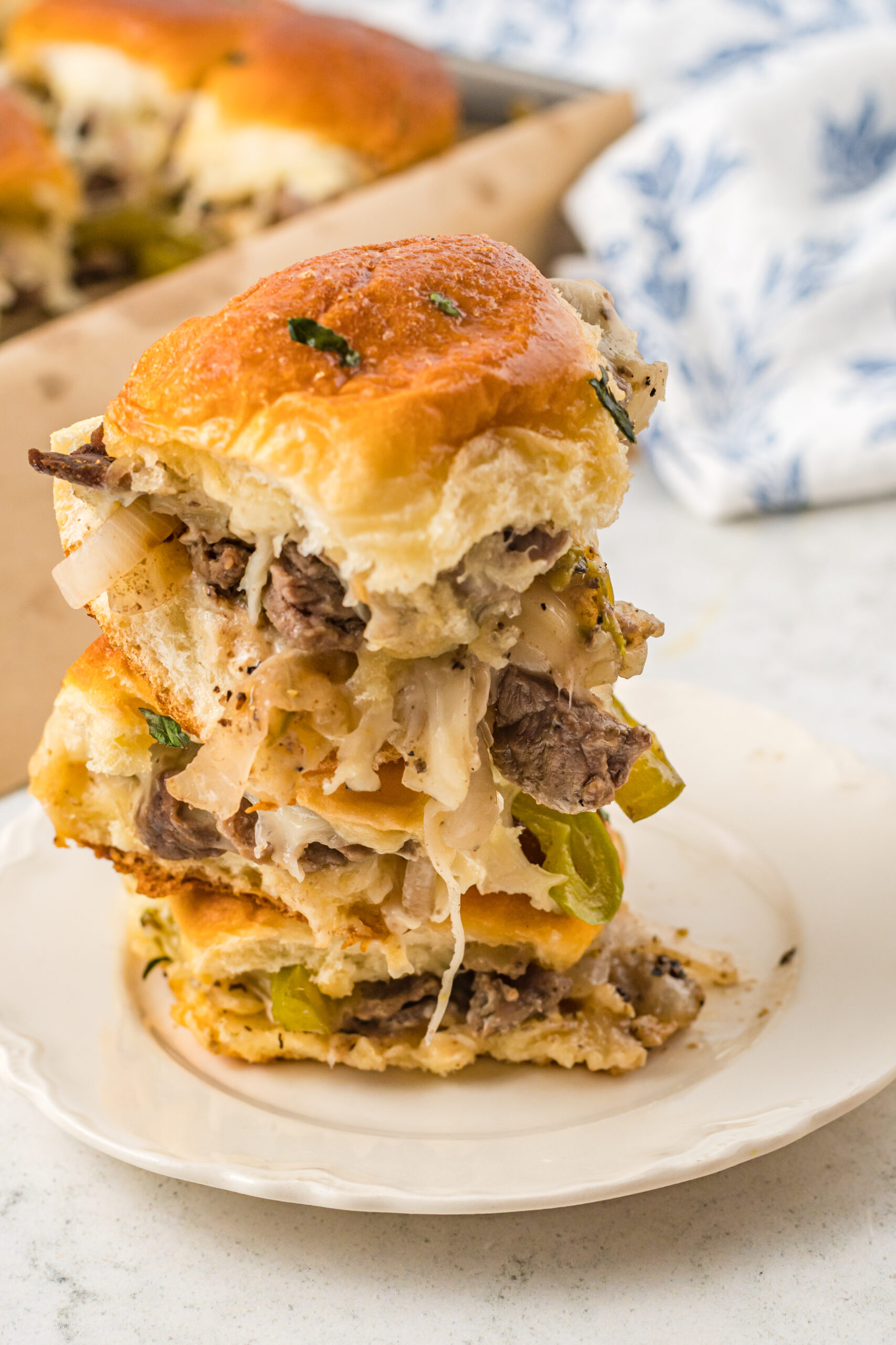 Three sliders stacked on a white plate. 