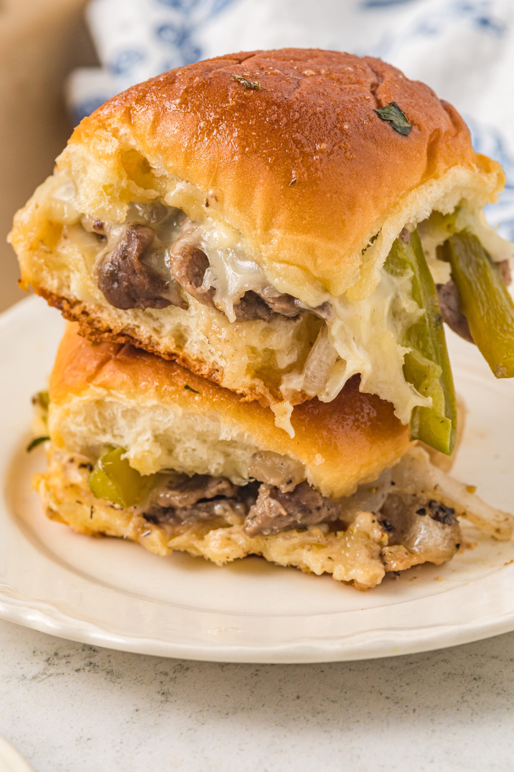 Two sliders stacked on a white plate. 