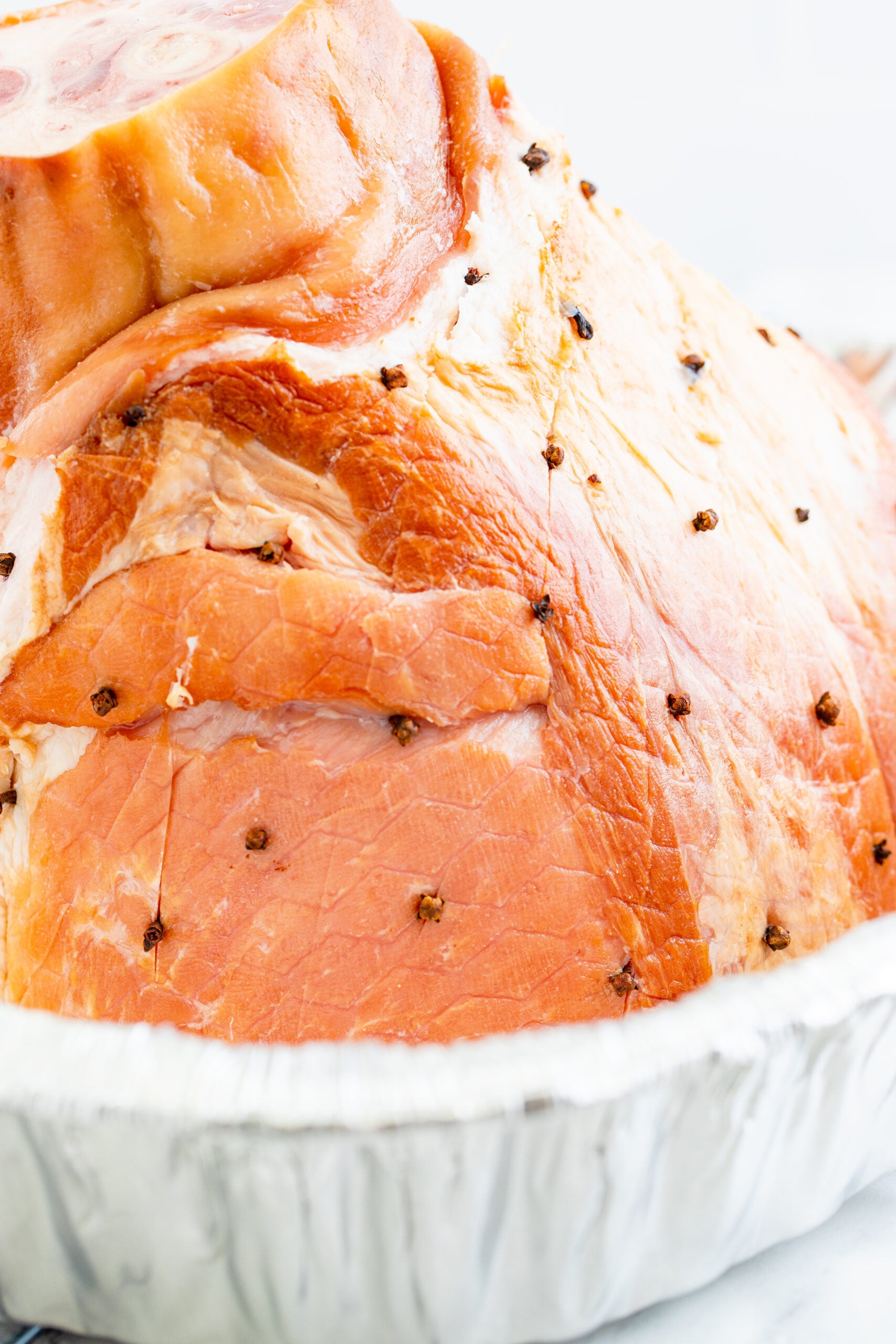 placing whole cloves into the side of the ham.