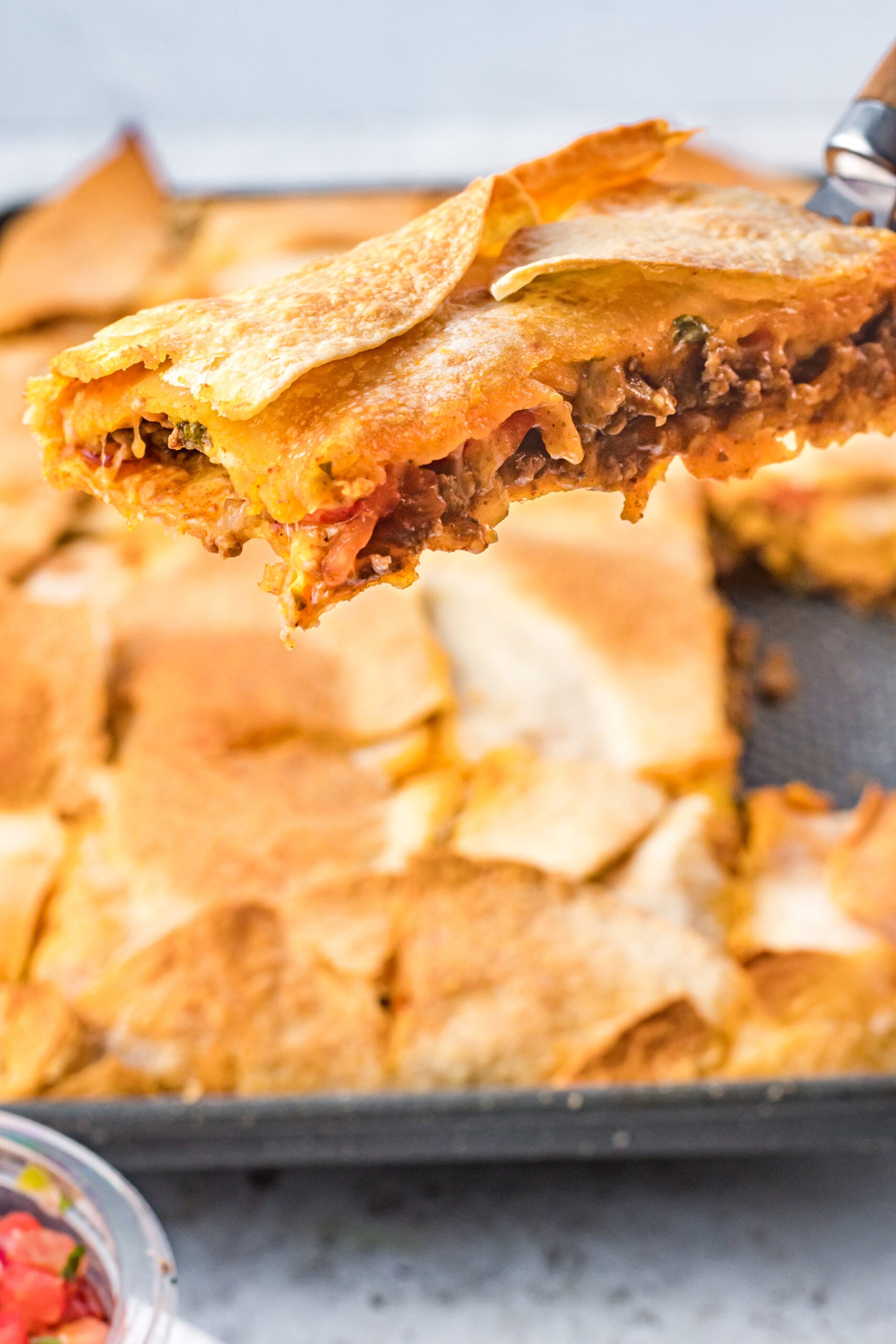 A piece of sheet pan tacos being removed from the baking sheet. 