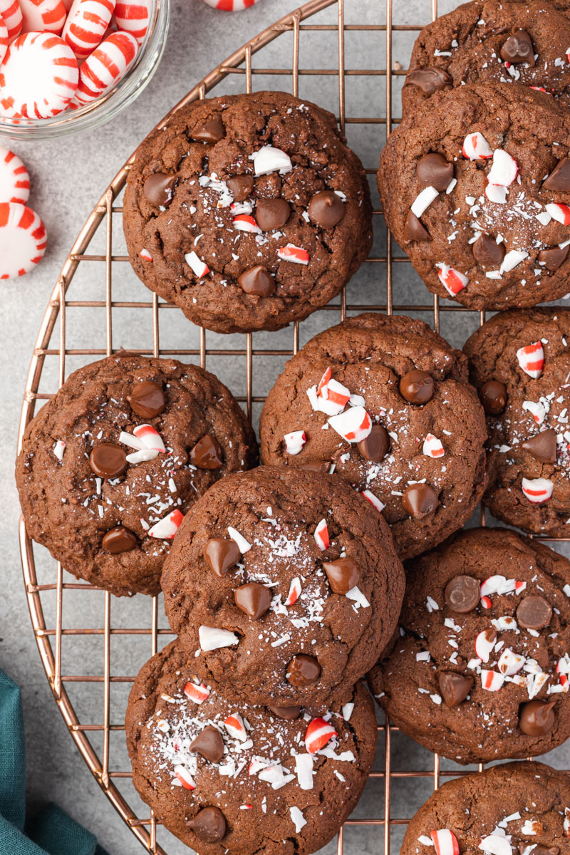 Chocolate Peppermint Cookies stacked on a rose gold cooling rack. 