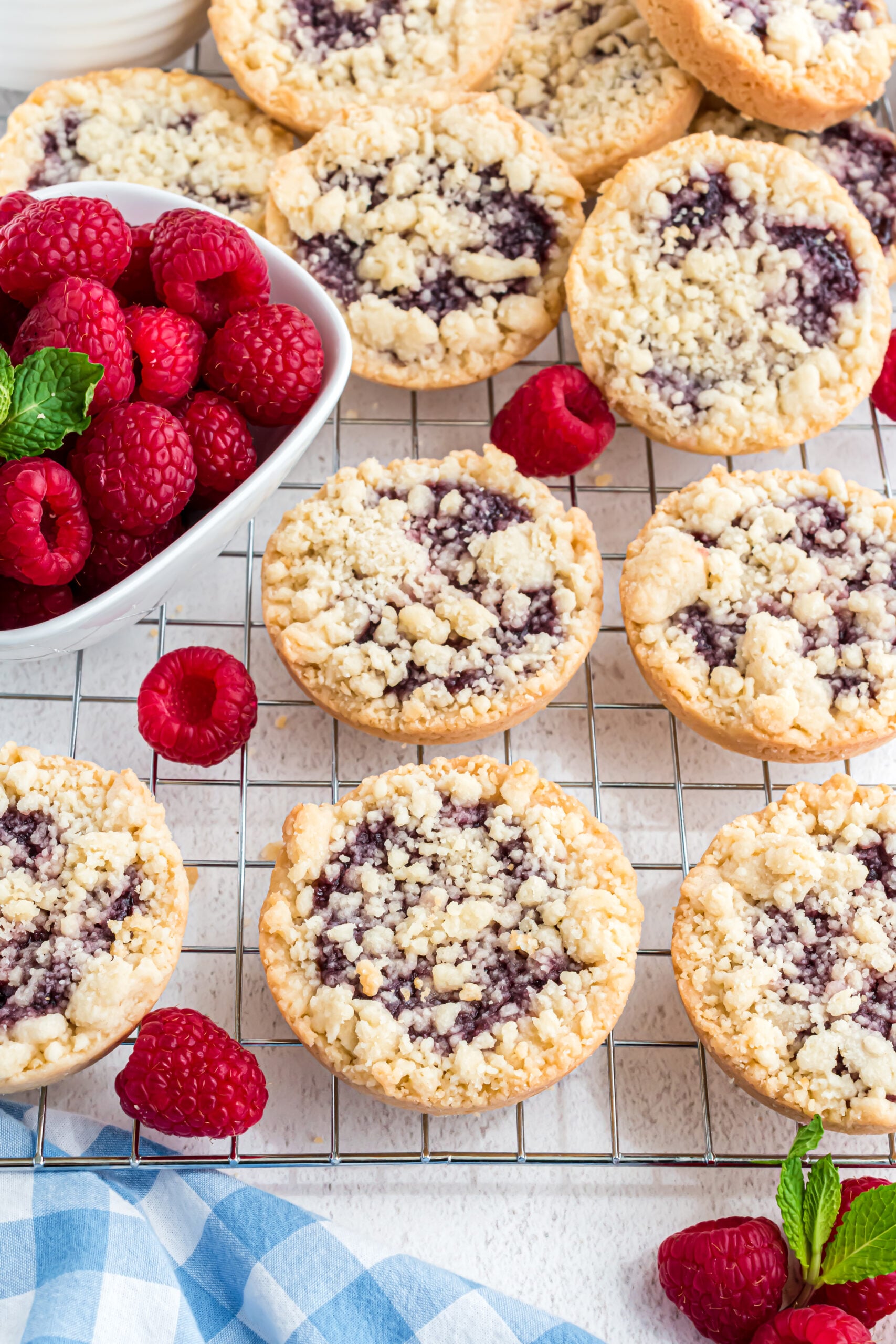 Overhead shot of the cookies on a wire rack with fresh raspberries.