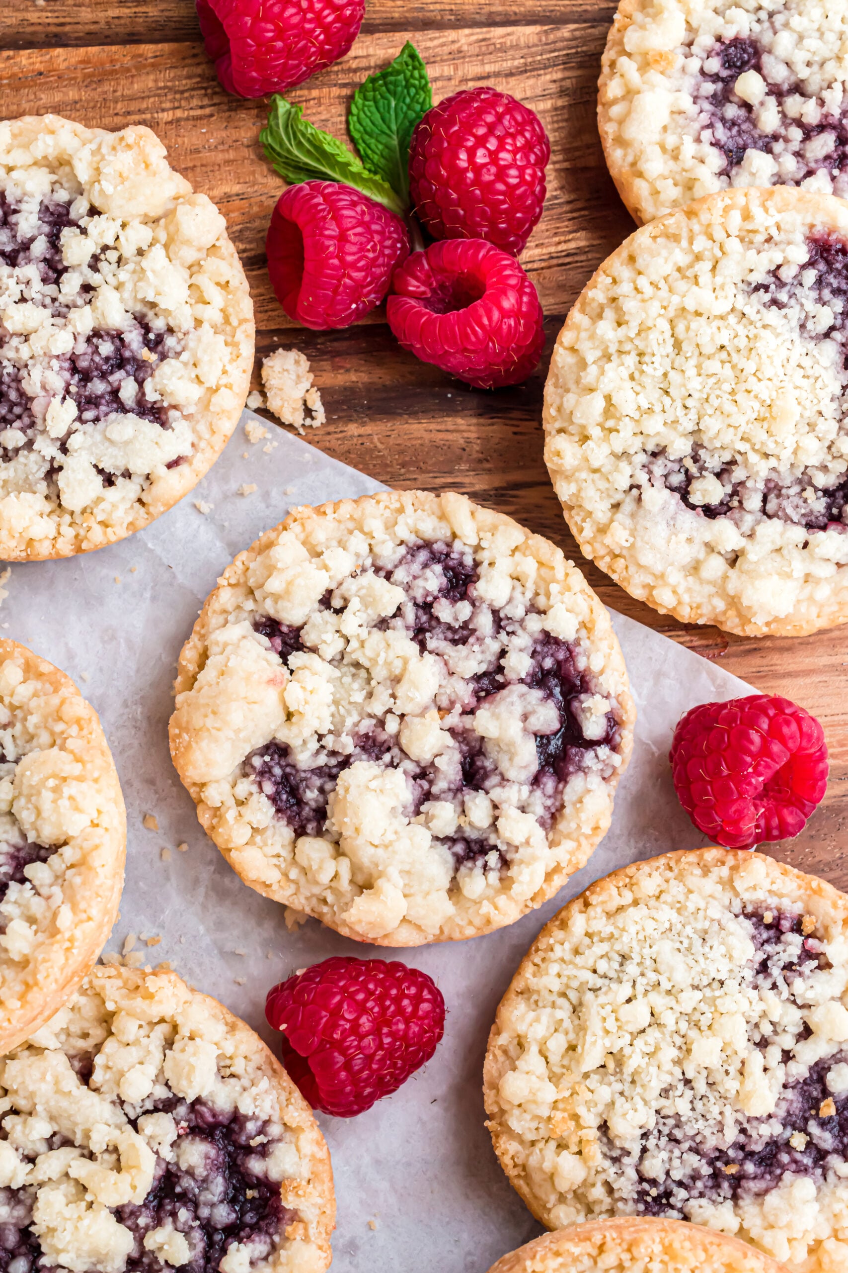Overhead shot of the cookies on wax paper with fresh raspberries.