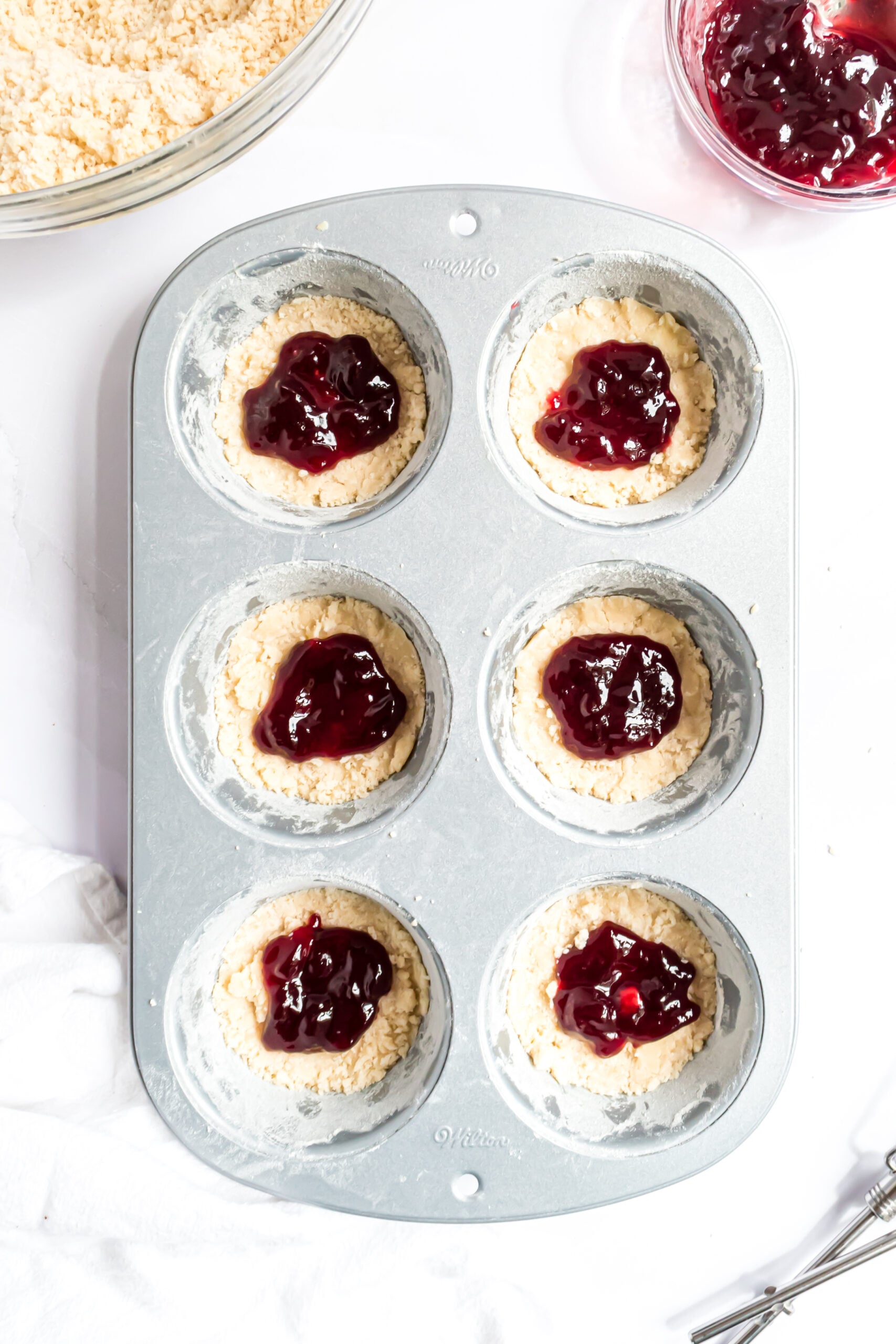 Overhead shot of the raspberry filling in the muffin tins.