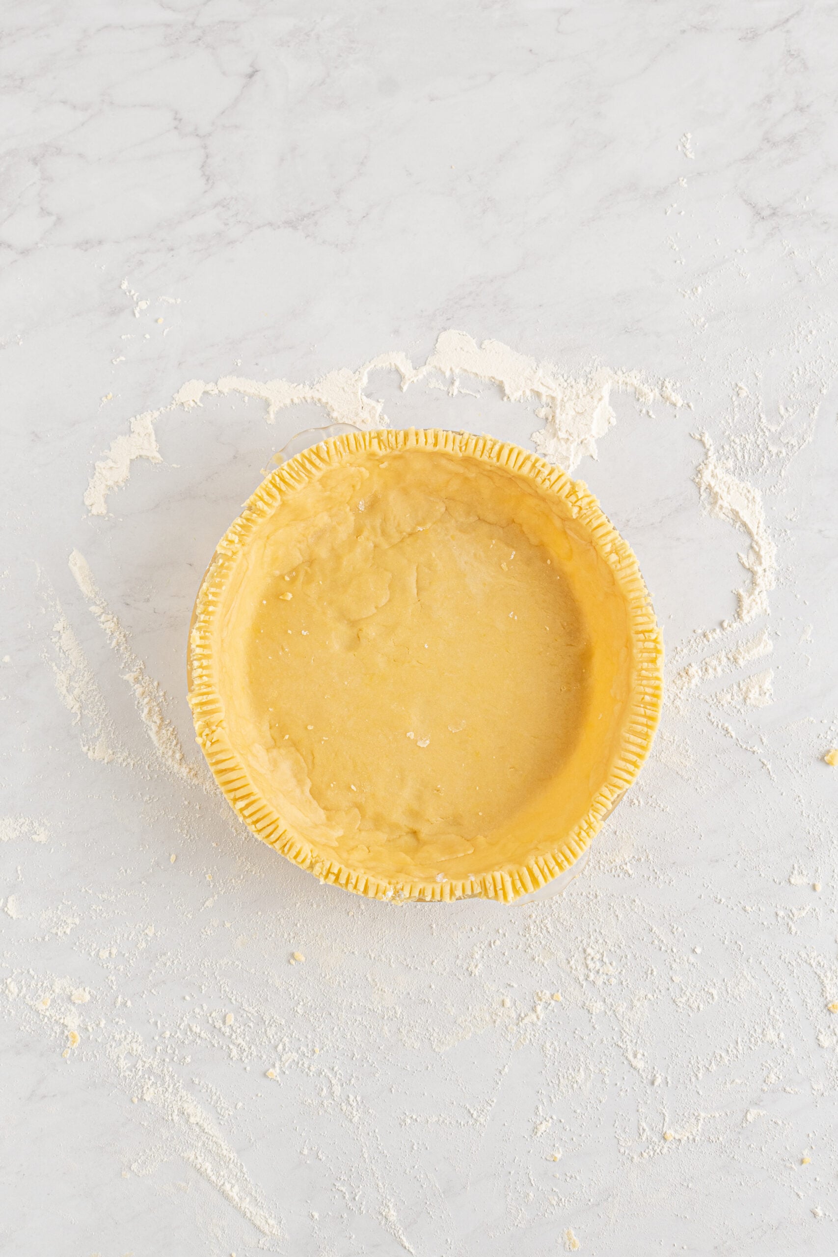 Overhead shot of the unbaked crust in the pie dish. 