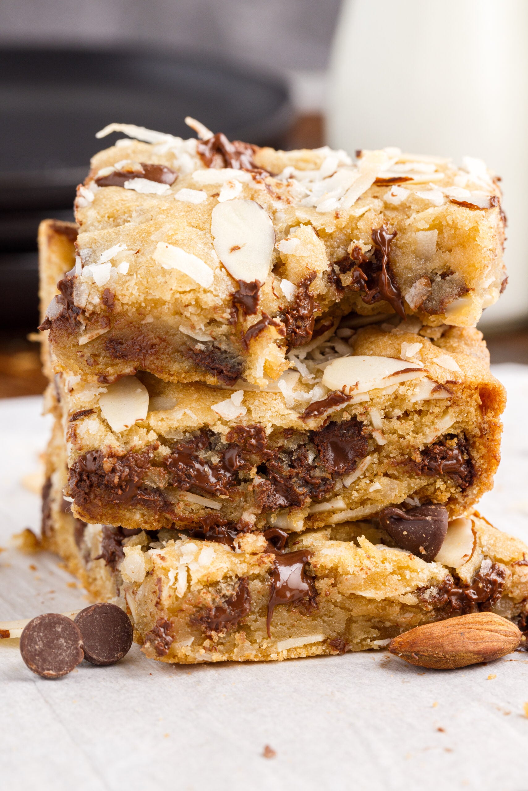 Three Almond Joy Cookie bars stacked on top of each other with a bite taken out of the top bar.