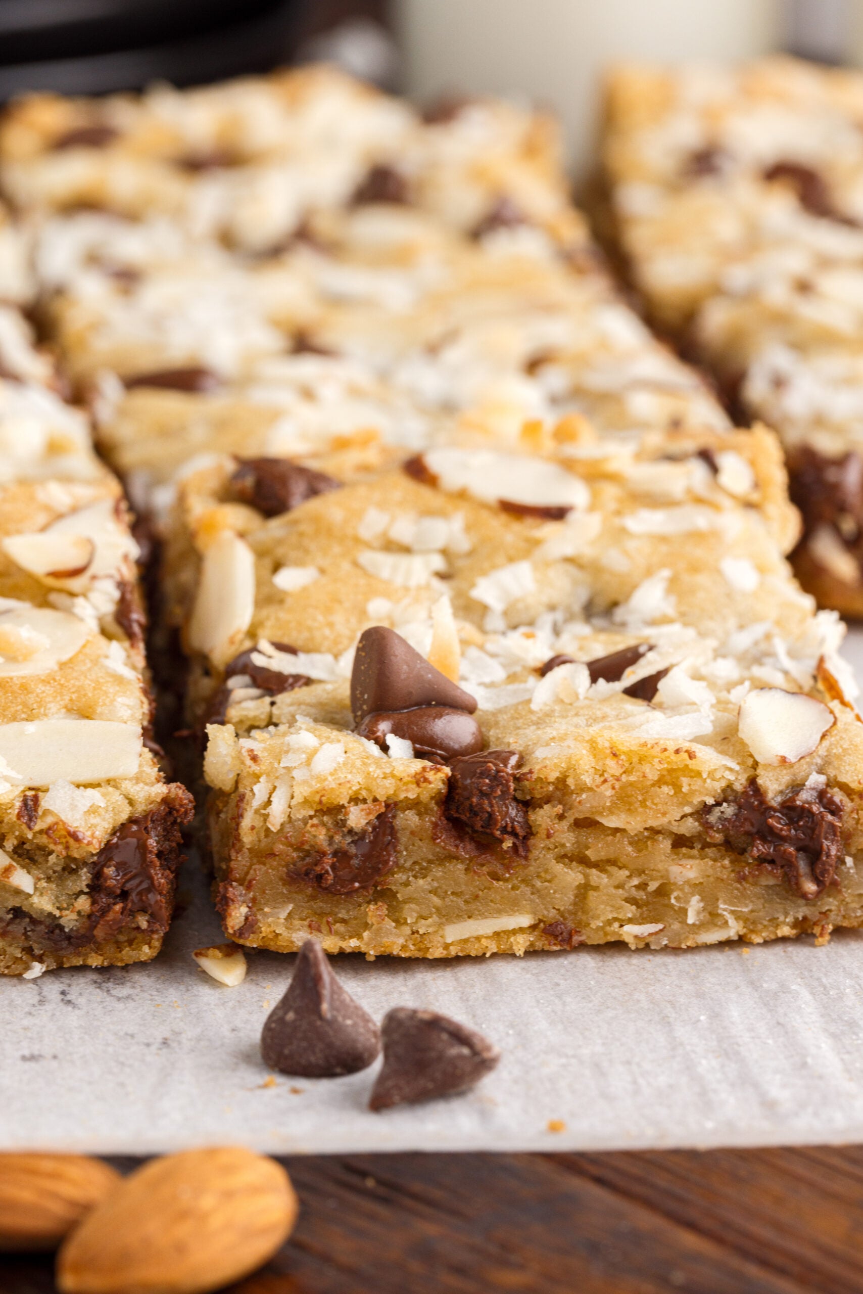 Side view of the almond joy cookie bars on a piece of parchment paper.
