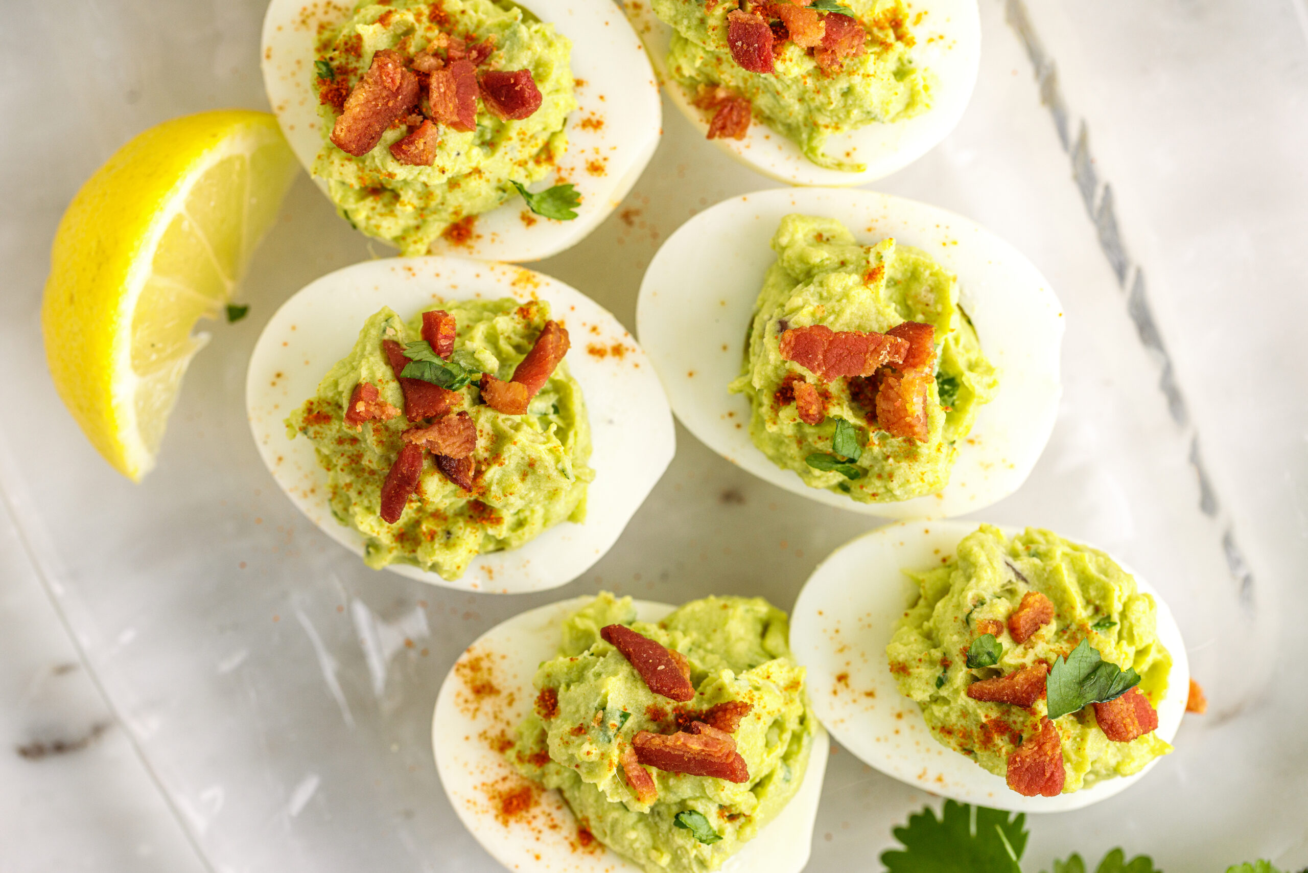 Overhead view of the deviled eggs topped with with chopped bacon.