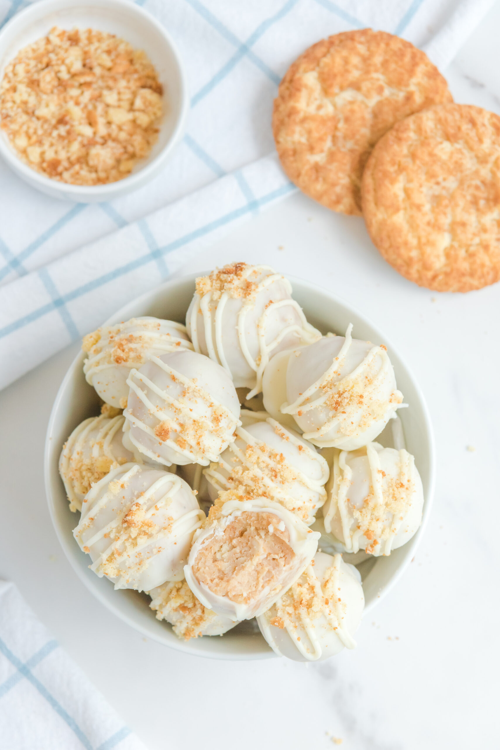 An overhead shot of snickerdoodle truffles in a white bowl topped with crushed snickerdoodles.